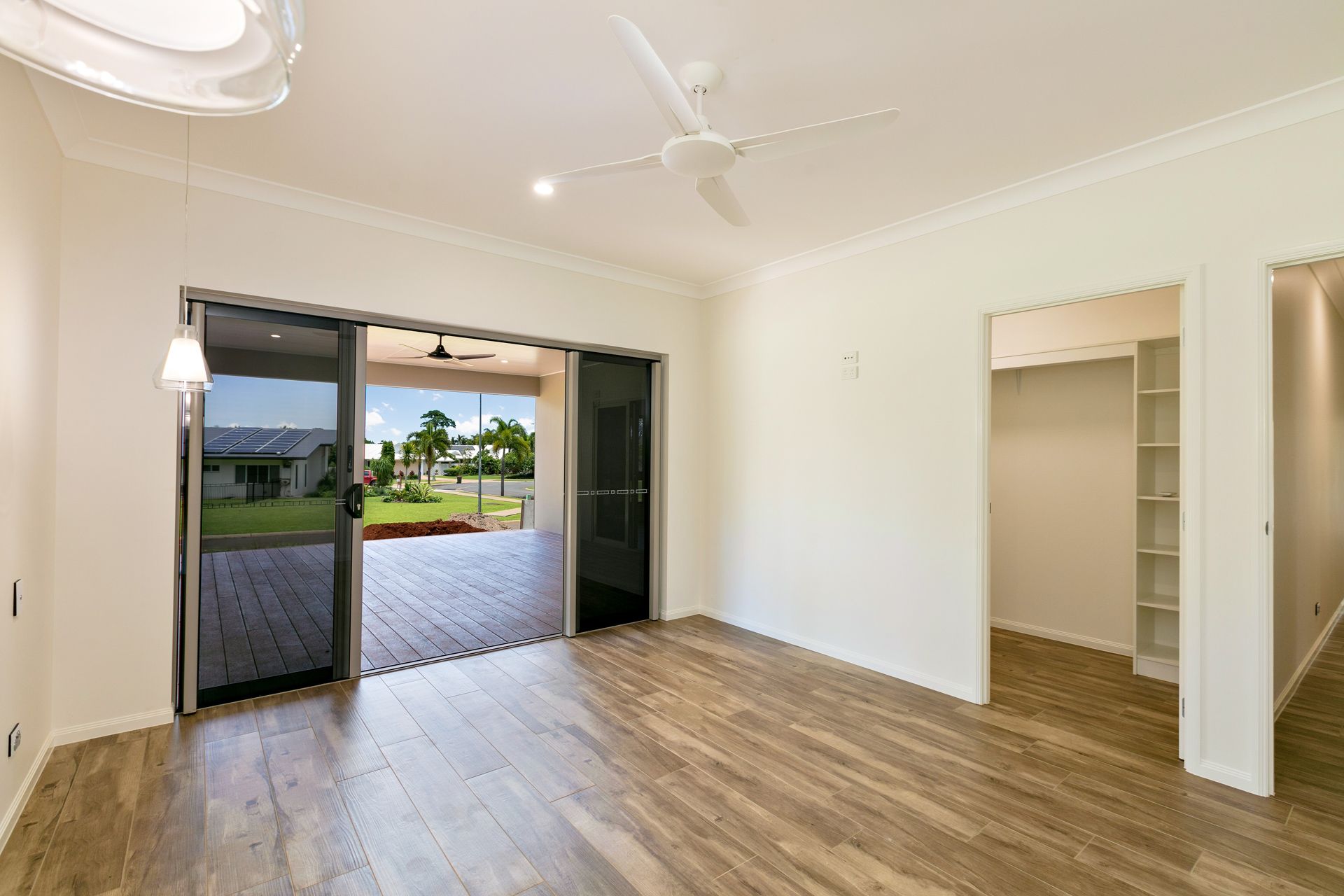 An Empty, Brightly Lit Bedroom With Light Wood-look Flooring — Ashlee Jones Homes in Gordonvale, QLD