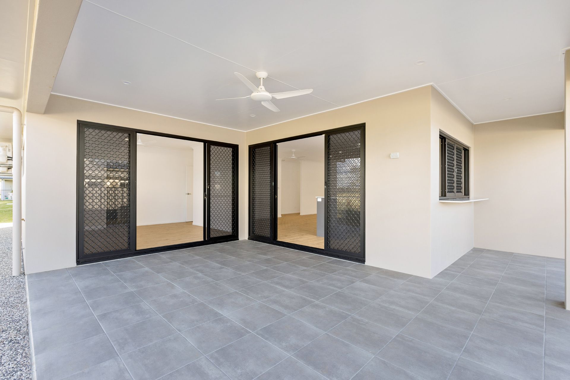 A Modern Patio With Grey Tiled Floors, Beige Walls — Ashlee Jones Homes in Gordonvale, QLD