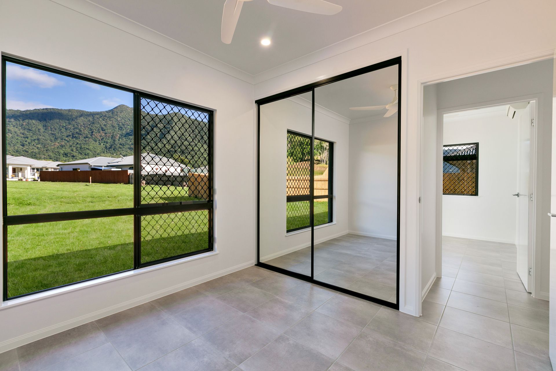 An Empty, Bright Room With White Walls, Tiled Floors — Ashlee Jones Homes in Gordonvale, QLD