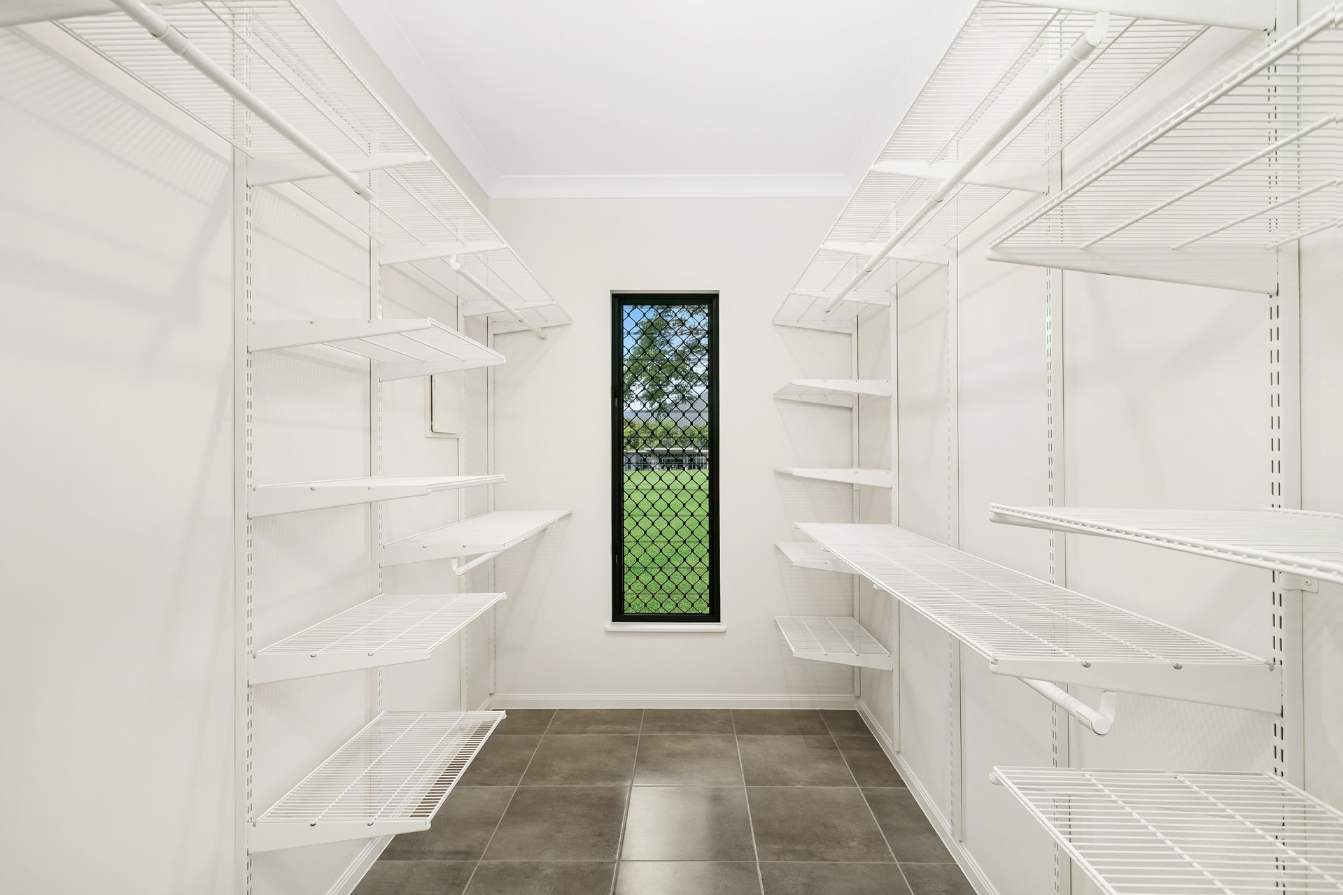A Walk-in Closet With White Wire Shelving on Both Walls — Ashlee Jones Homes in Gordonvale, QLD