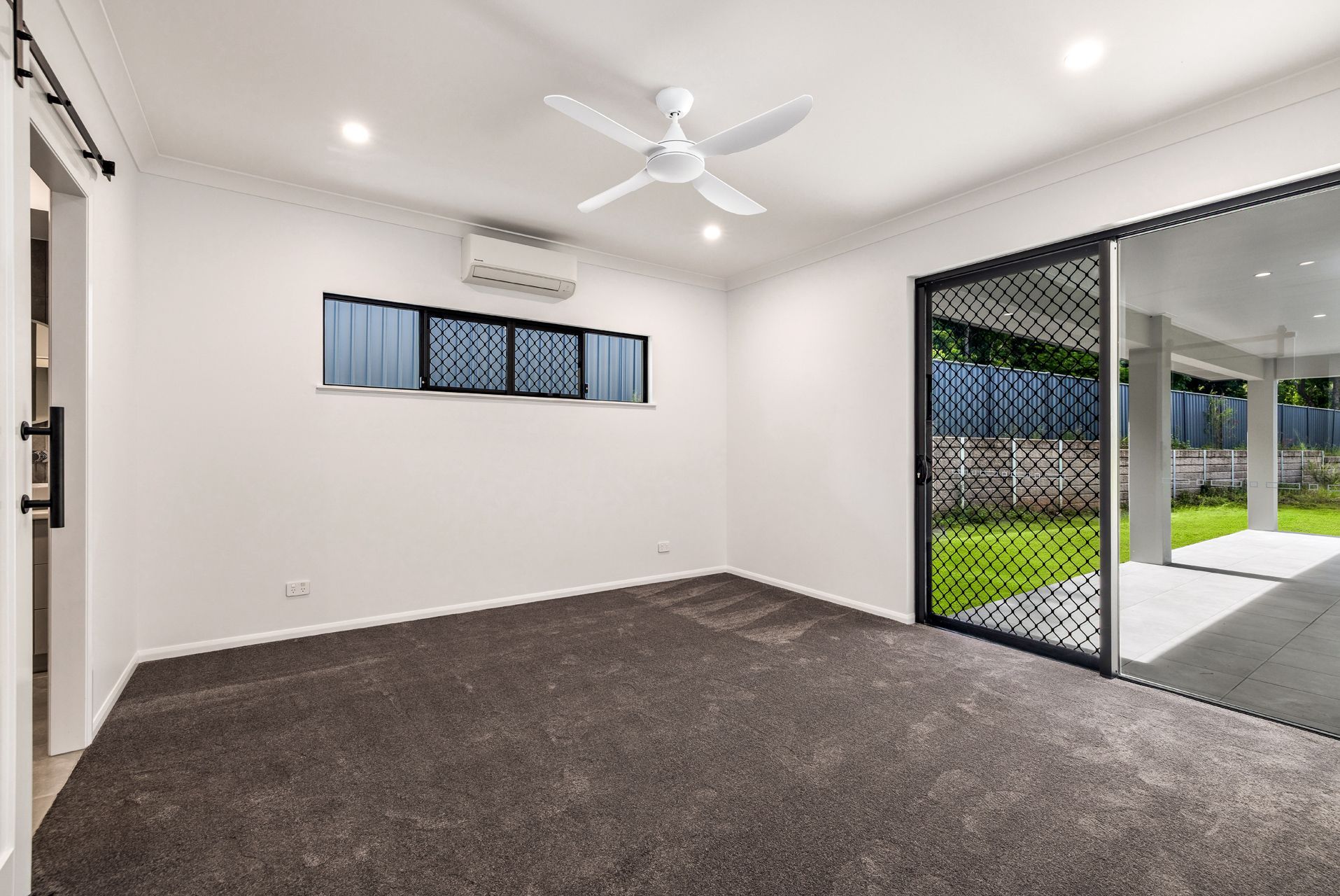 A Vacant Room With White Walls, Dark Gray Carpet — Ashlee Jones Homes in Gordonvale, QLD