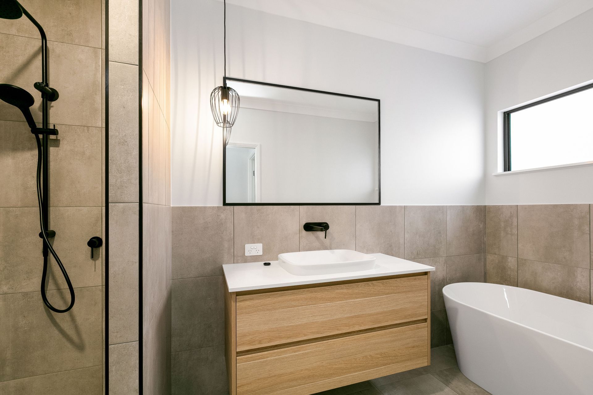 Modern Bathroom Featuring a Wood Vanity With a White Vessel Sink — Ashlee Jones Homes in Gordonvale, QLD