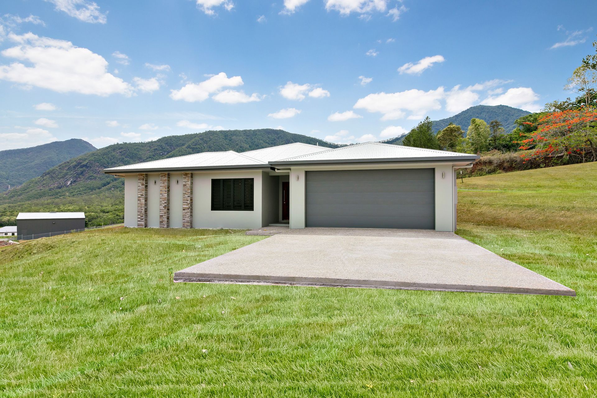 A Modern, Light-colored Single-story House With a Double Garage Sits — Ashlee Jones Homes in Gordonvale, QLD