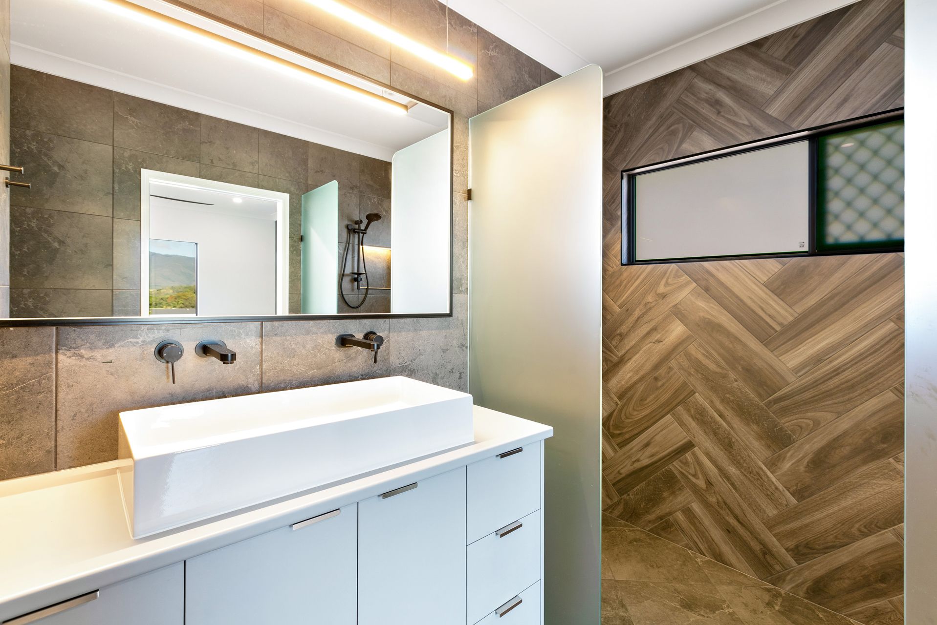 A Modern Bathroom Vanity With a White Vessel Sink — Ashlee Jones Homes in Gordonvale, QLD