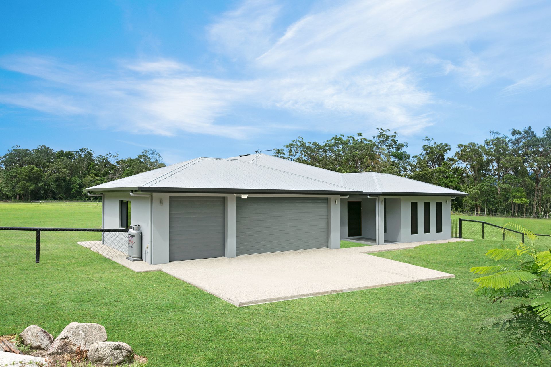 A Single-story, Light Gray House With a Metal Roof and a Double Garage — Ashlee Jones Homes in Gordonvale, QLD