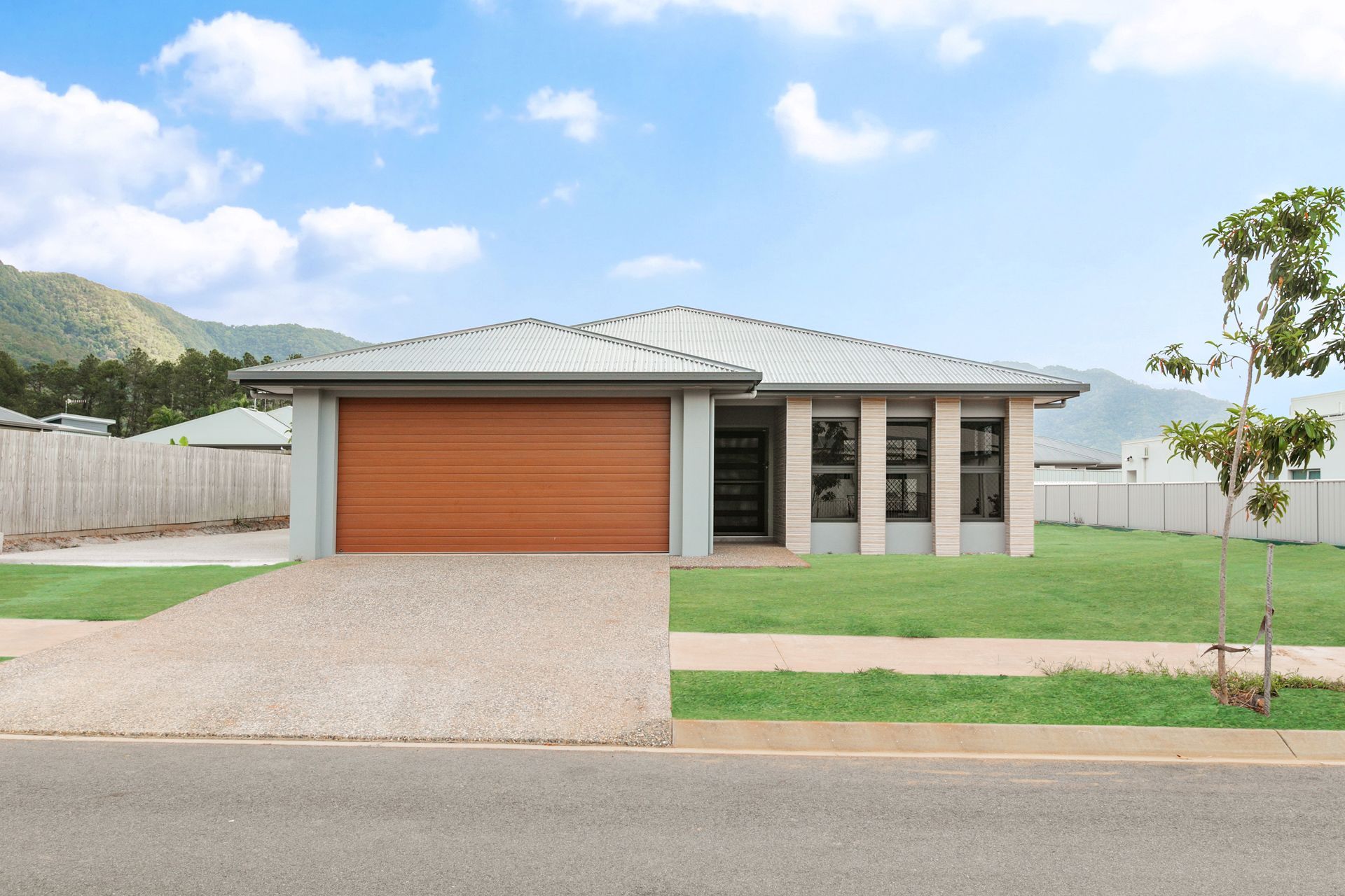 Single-story Suburban House With a Wood-grain Garage Door — Ashlee Jones Homes in Gordonvale, QLD
