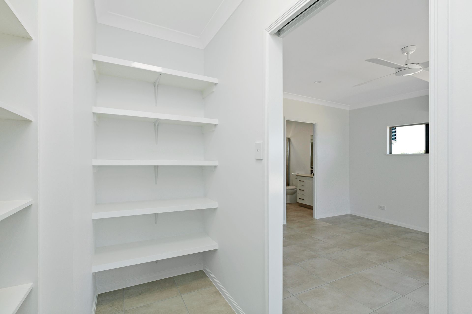 A Walk-in Pantry With White Shelves, Leading — Ashlee Jones Homes in Gordonvale, QLD