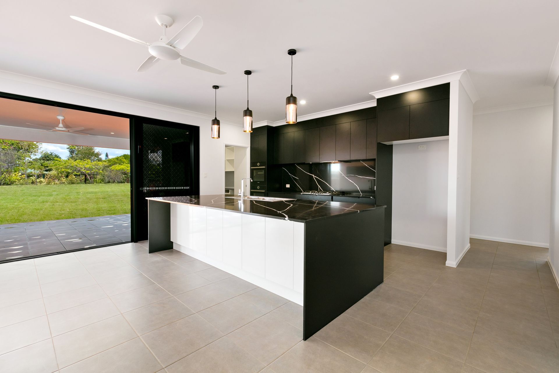 A Modern, Minimalist Kitchen With a White and Black Island — Ashlee Jones Homes in Gordonvale, QLD