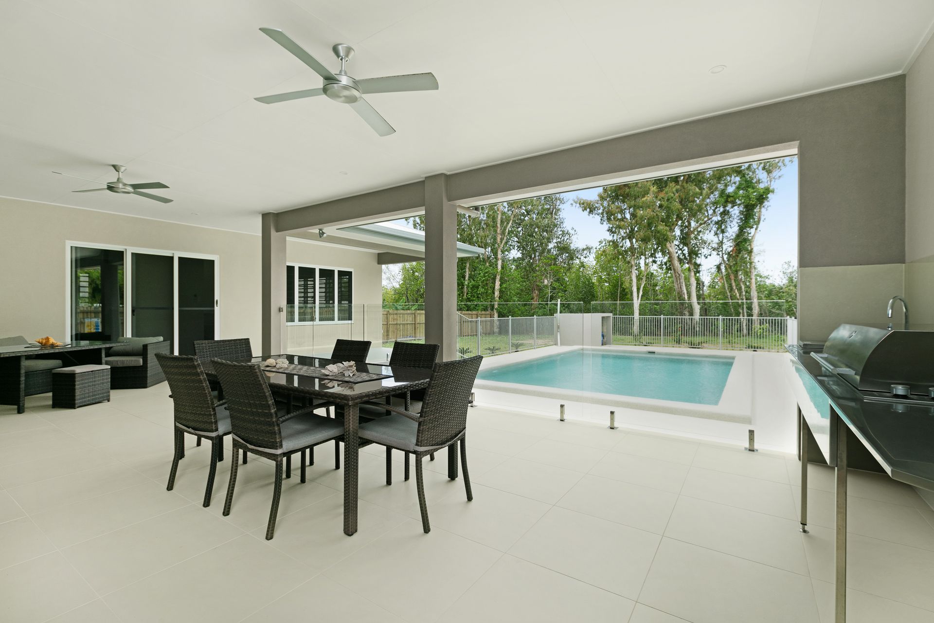 A Covered Outdoor Patio Featuring a Dining Table With Six Chairs — Ashlee Jones Homes in Gordonvale, QLD