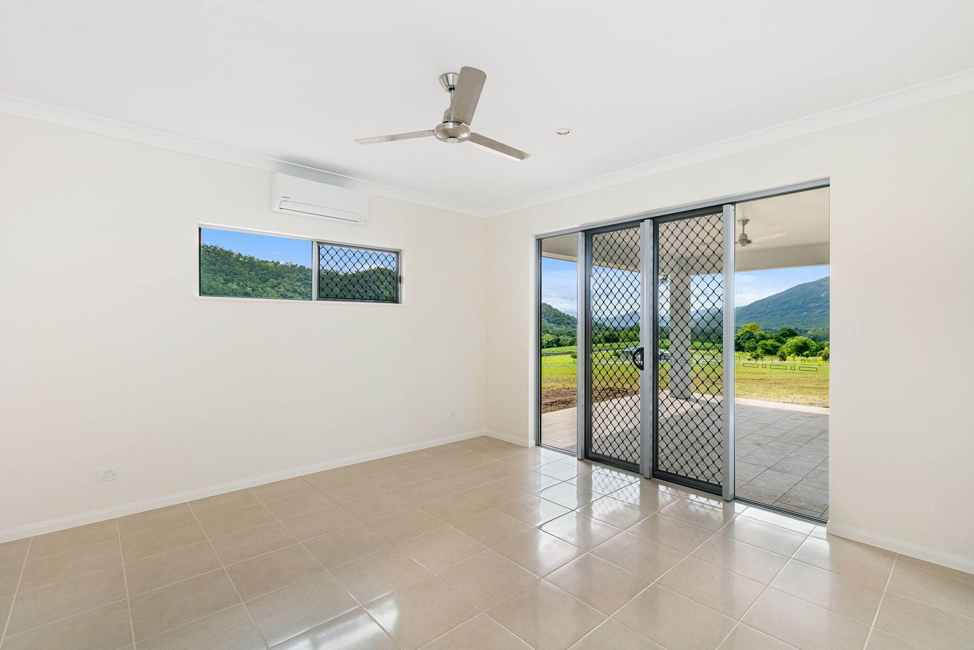 A Bright, Empty Room With Light Tile Floors, White Walls — Ashlee Jones Homes in Gordonvale, QLD