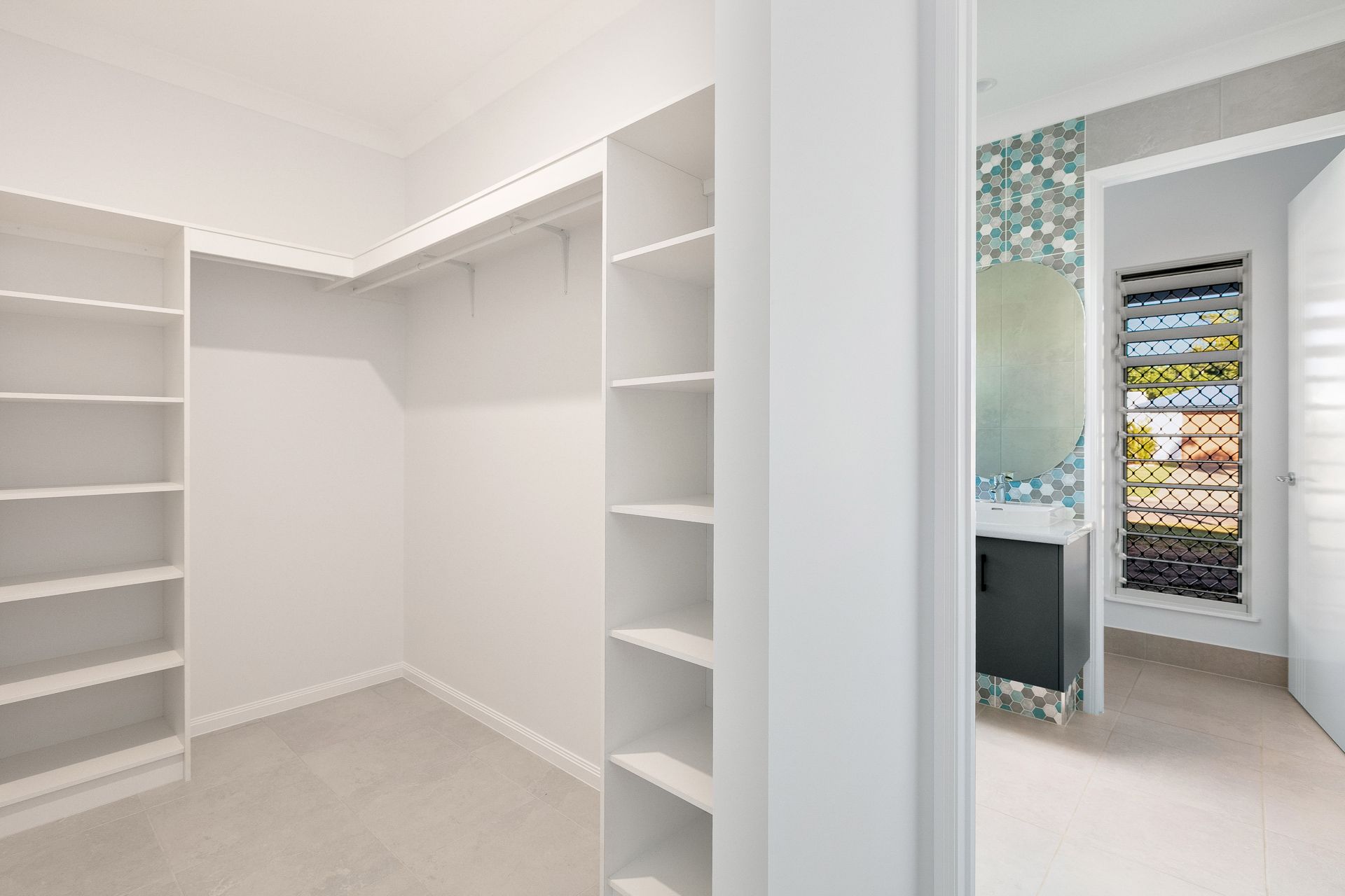 A White, Modern Walk-in Closet With Shelves and Rods — Ashlee Jones Homes in Gordonvale, QLD