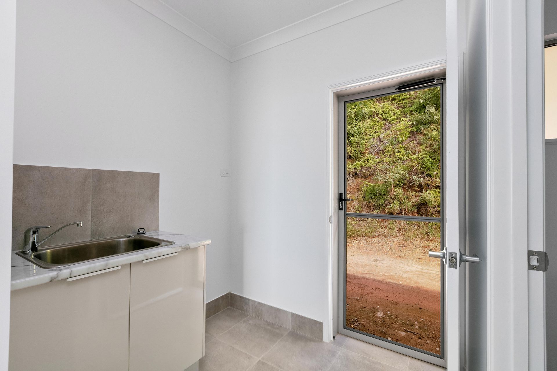 A Modern Laundry Room With a Stainless Steel Sink — Ashlee Jones Homes in Gordonvale, QLD