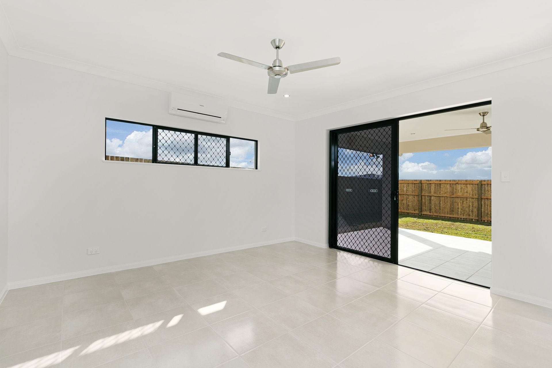 An Empty, Bright Room With White Walls, Tiled Floors — Ashlee Jones Homes in Gordonvale, QLD