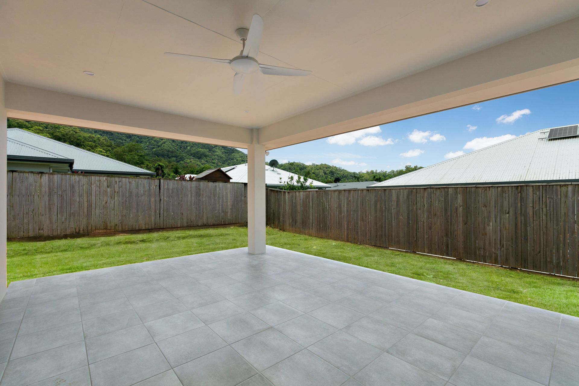 A Covered Concrete Patio With a Ceiling Fan — Ashlee Jones Homes in Gordonvale, QLD
