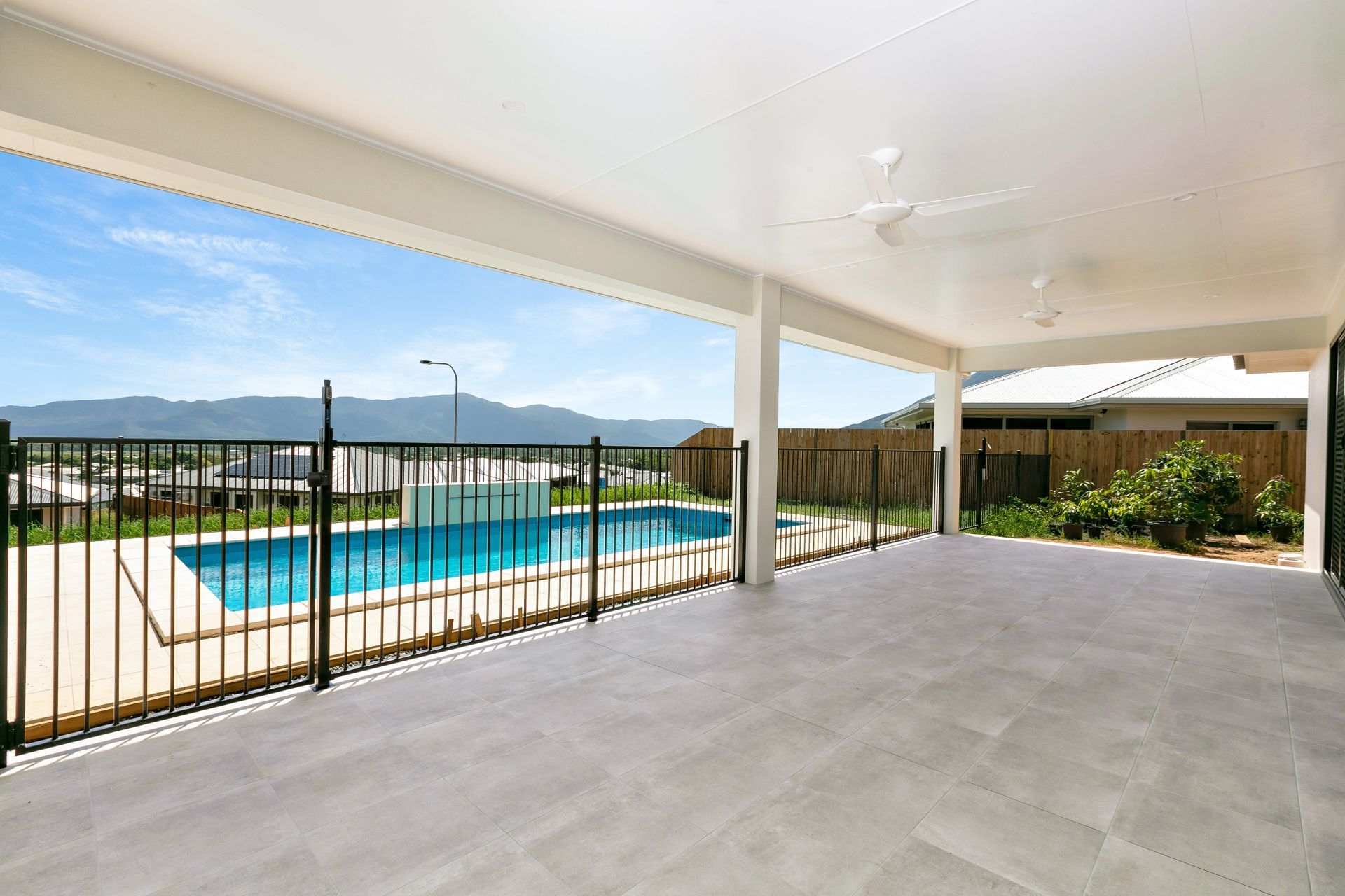 A Covered Outdoor Patio Featuring Light-colored Tiles — Ashlee Jones Homes in Gordonvale, QLD