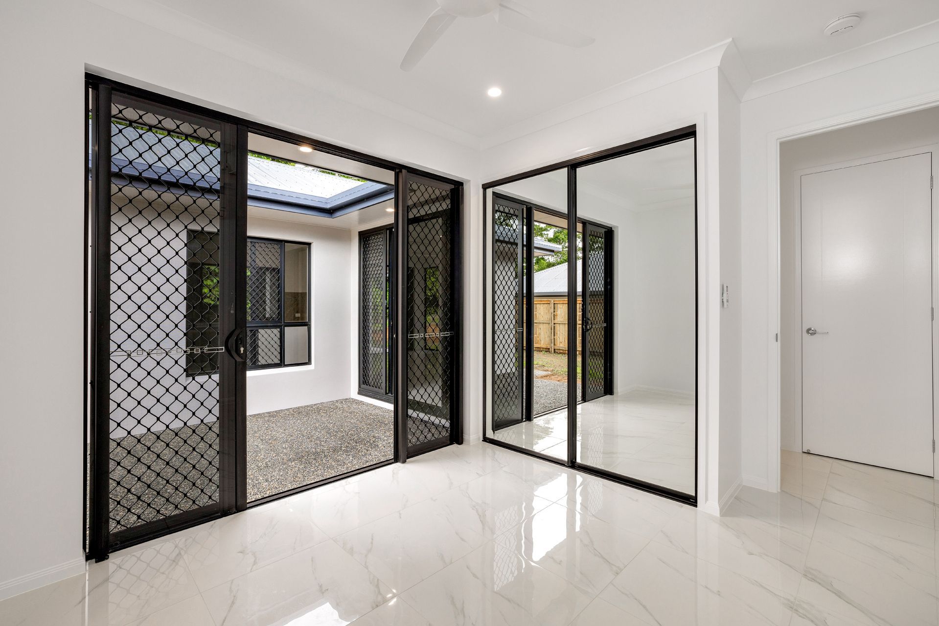A Bright, Modern Room With White Walls, Polished Marble Floors — Ashlee Jones Homes in Gordonvale, QLD