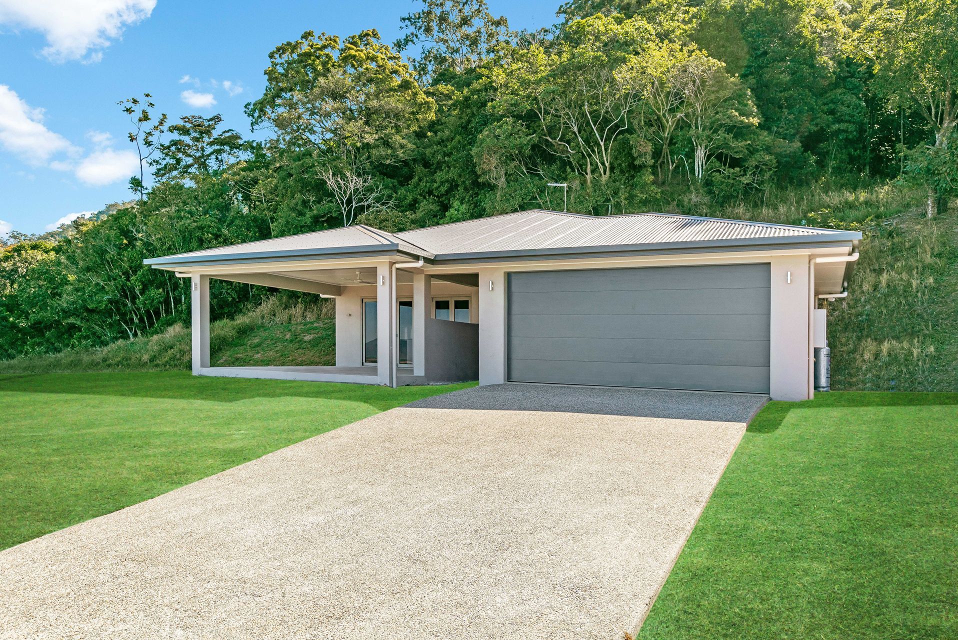 A Single-story, Light-colored House With a Large Garage and Attached Carport — Ashlee Jones Homes in Gordonvale, QLD