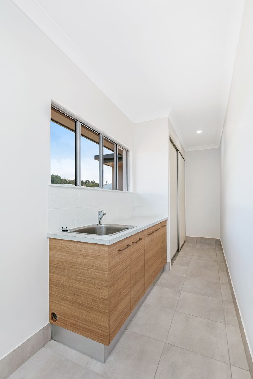 Modern Laundry Room With Wood-toned Cabinets — Ashlee Jones Homes in Gordonvale, QLD