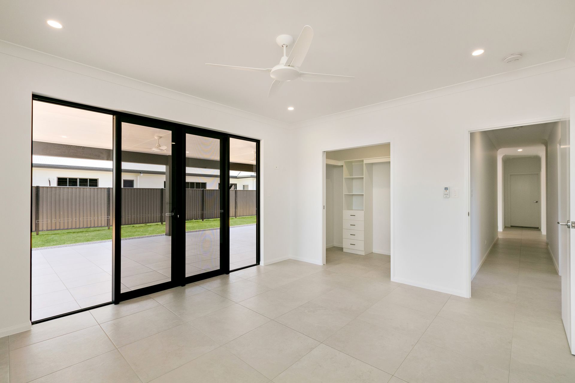 A Bright, Minimalist Room With Large Black-framed Glass Doors — Ashlee Jones Homes in Gordonvale, QLD