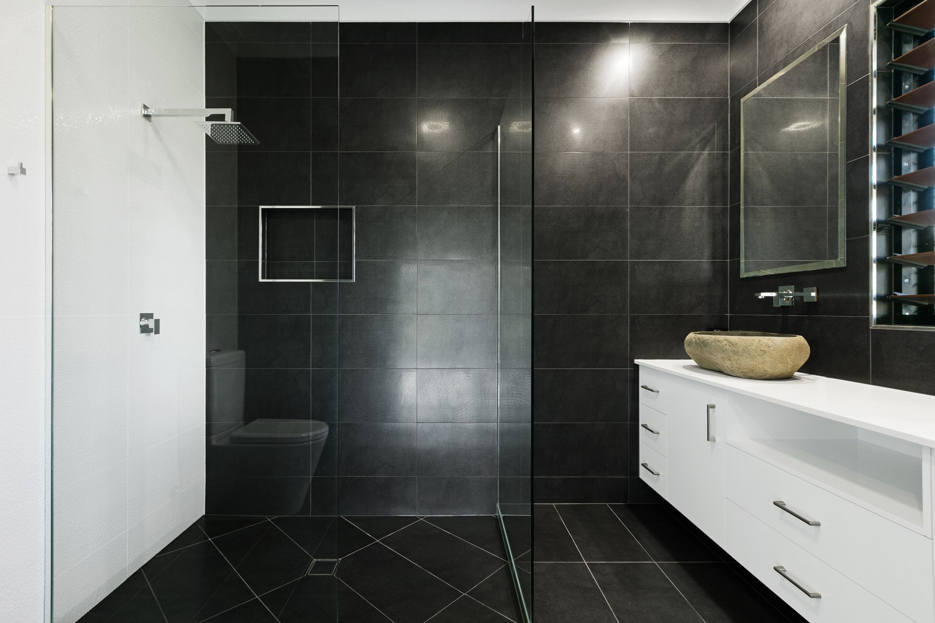 A Modern Bathroom Featuring a Black Tiled Walk-in Shower — Ashlee Jones Homes in Gordonvale, QLD