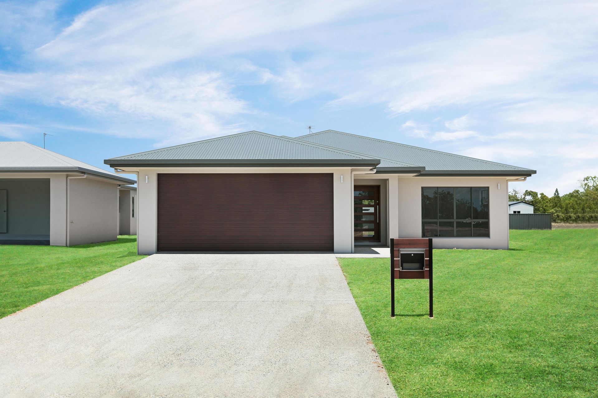 A Single-story Suburban House With a Dark Garage Door — Ashlee Jones Homes in Gordonvale, QLD