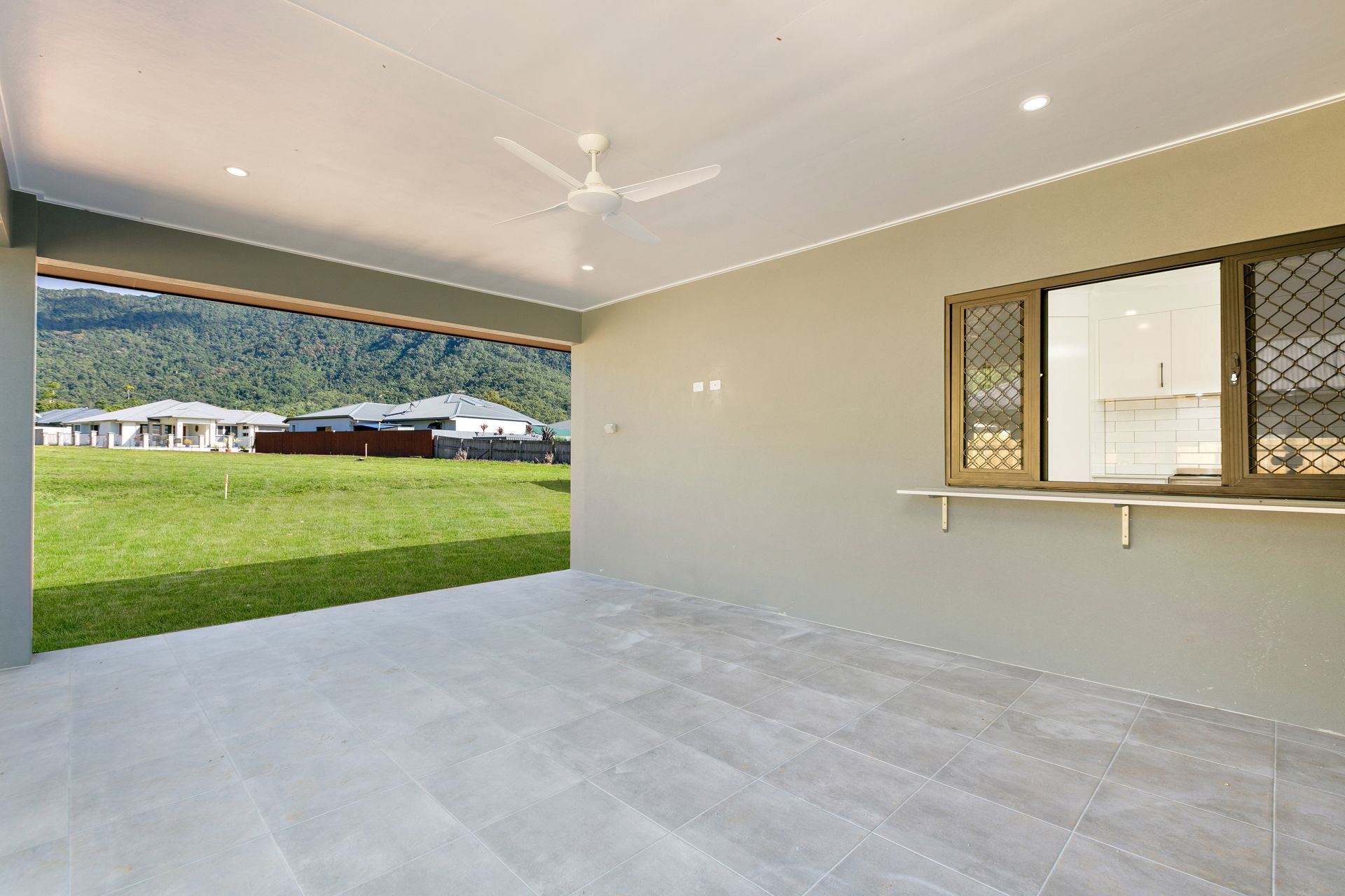 A Covered Patio With Light Grey Tile Flooring — Ashlee Jones Homes in Gordonvale, QLD