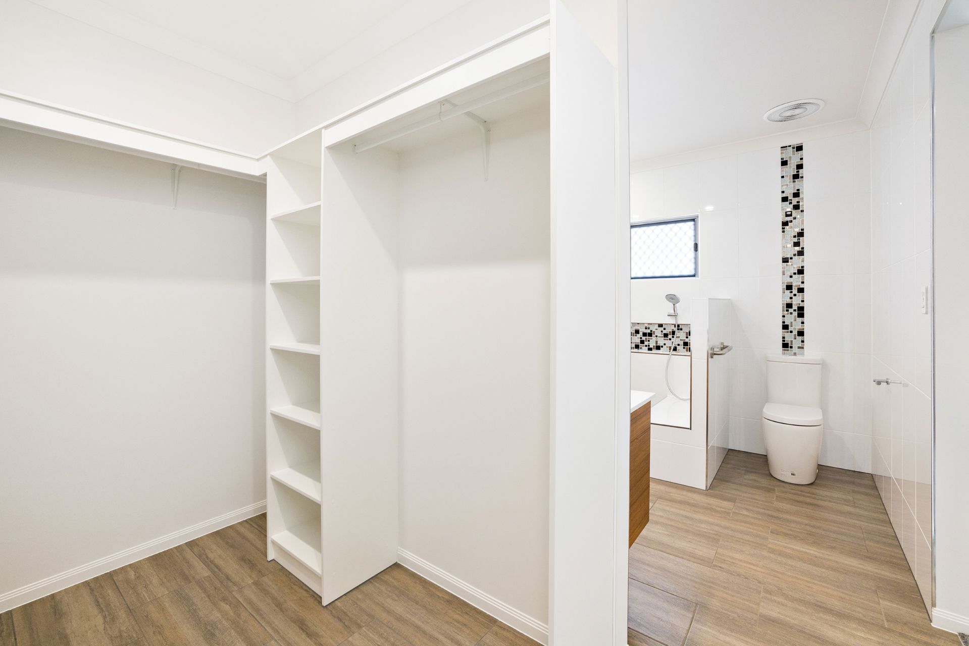 A Walk-in Closet With White Shelves and a Wall — Ashlee Jones Homes in Gordonvale, QLD
