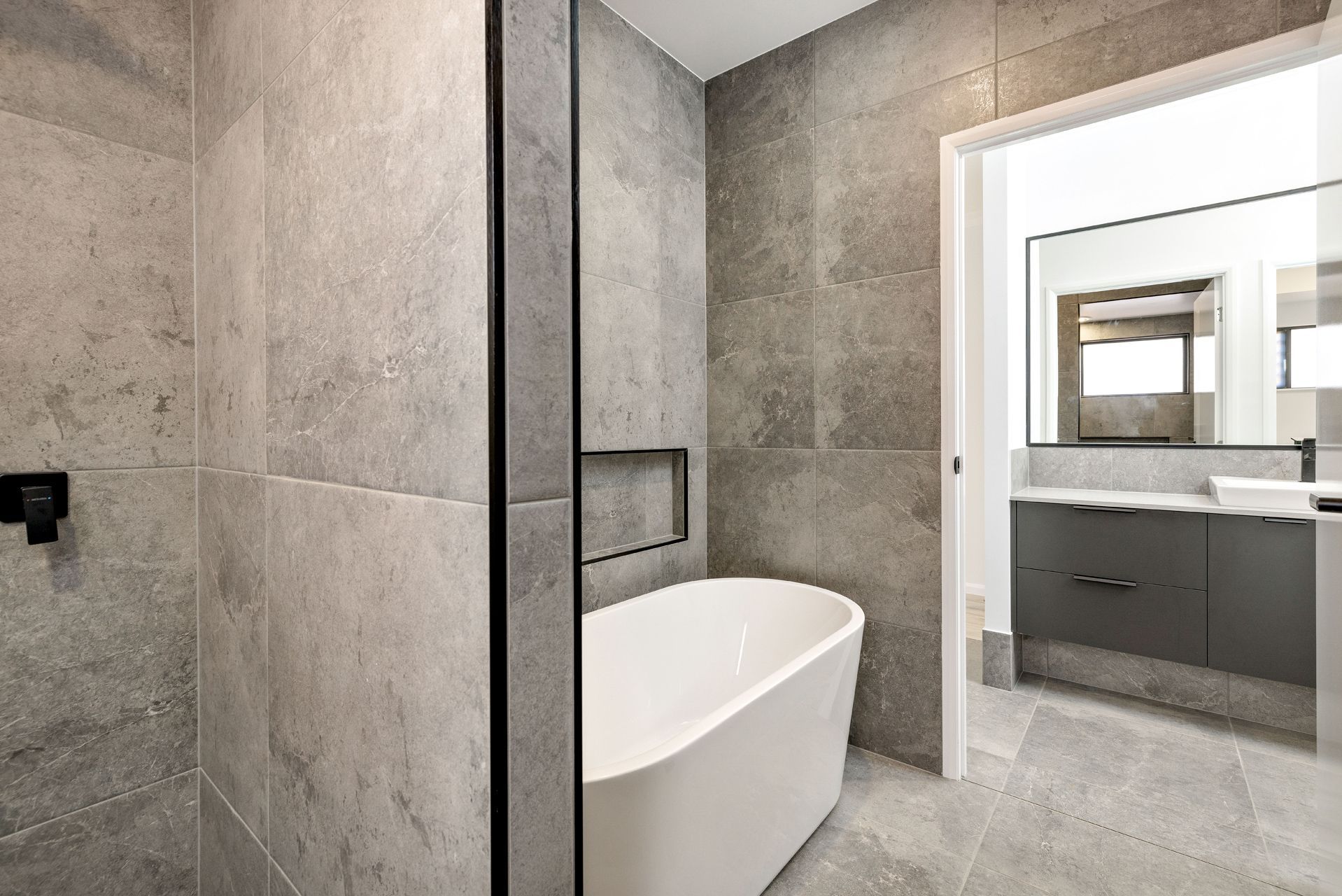A Modern Bathroom With Grey Stone Tiling — Ashlee Jones Homes in Gordonvale, QLD
