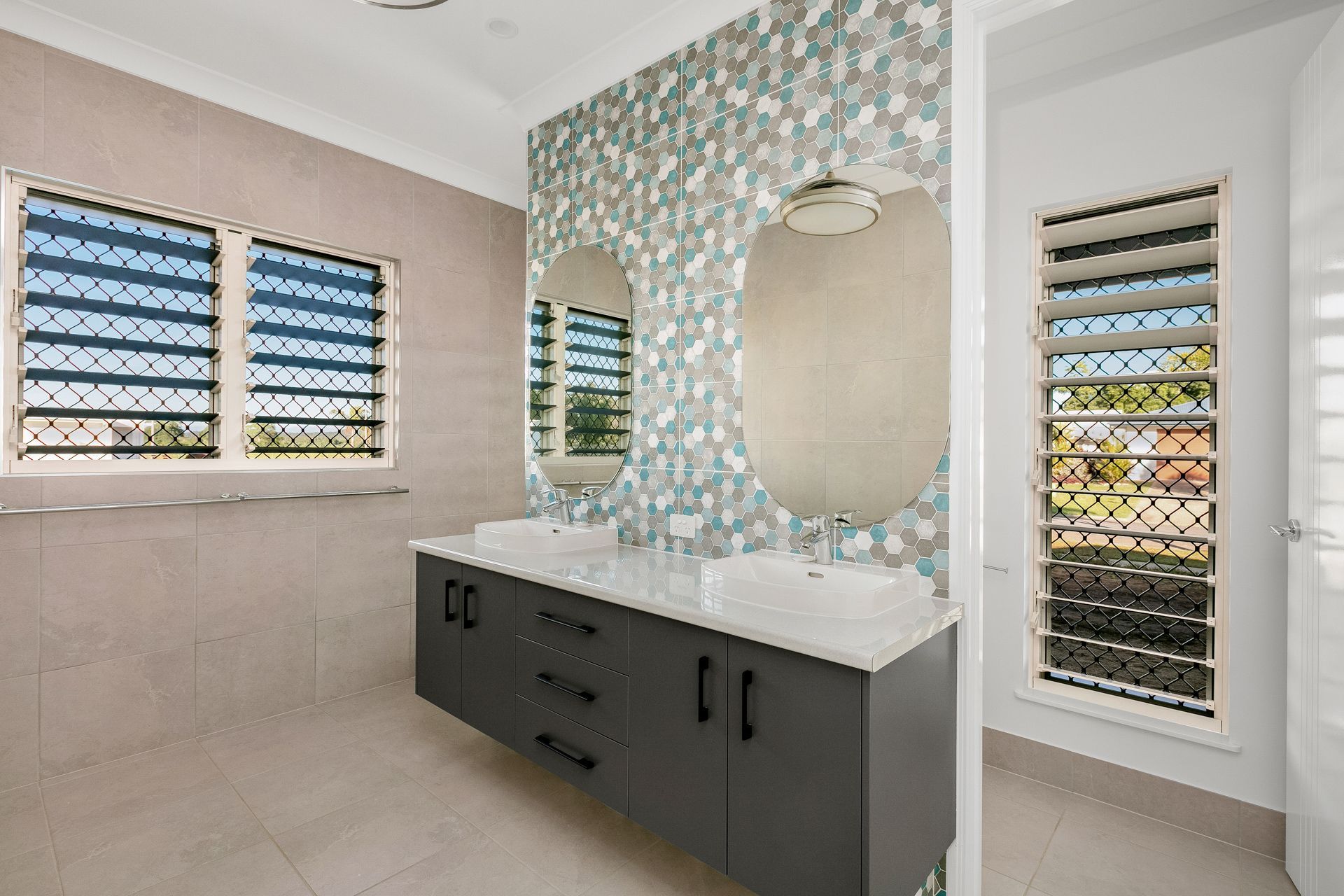 A Modern Bathroom With a Dark Double Vanity — Ashlee Jones Homes in Gordonvale, QLD