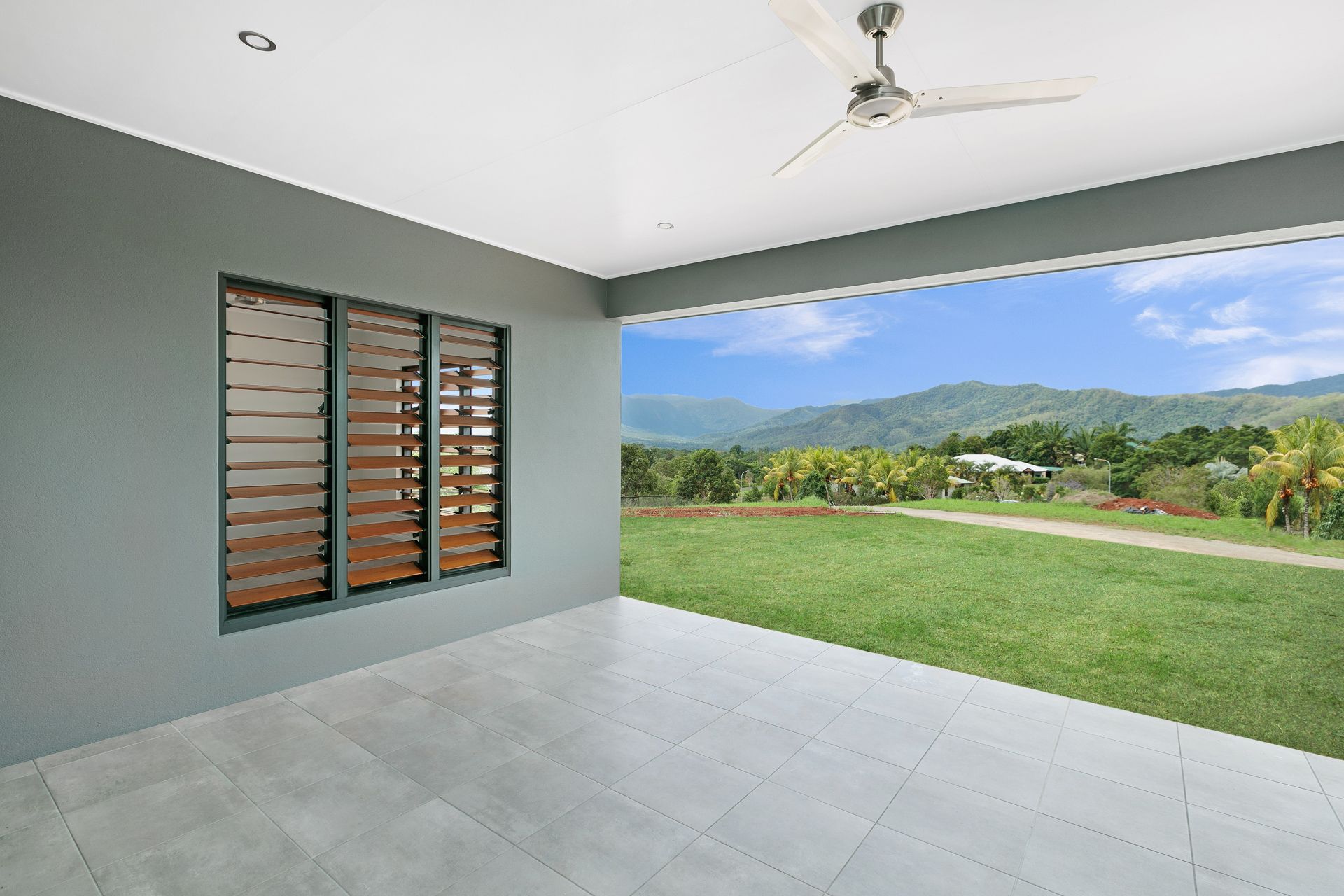 An Open-air Patio With Grey Walls, Tiled Floor — Ashlee Jones Homes in Gordonvale, QLD