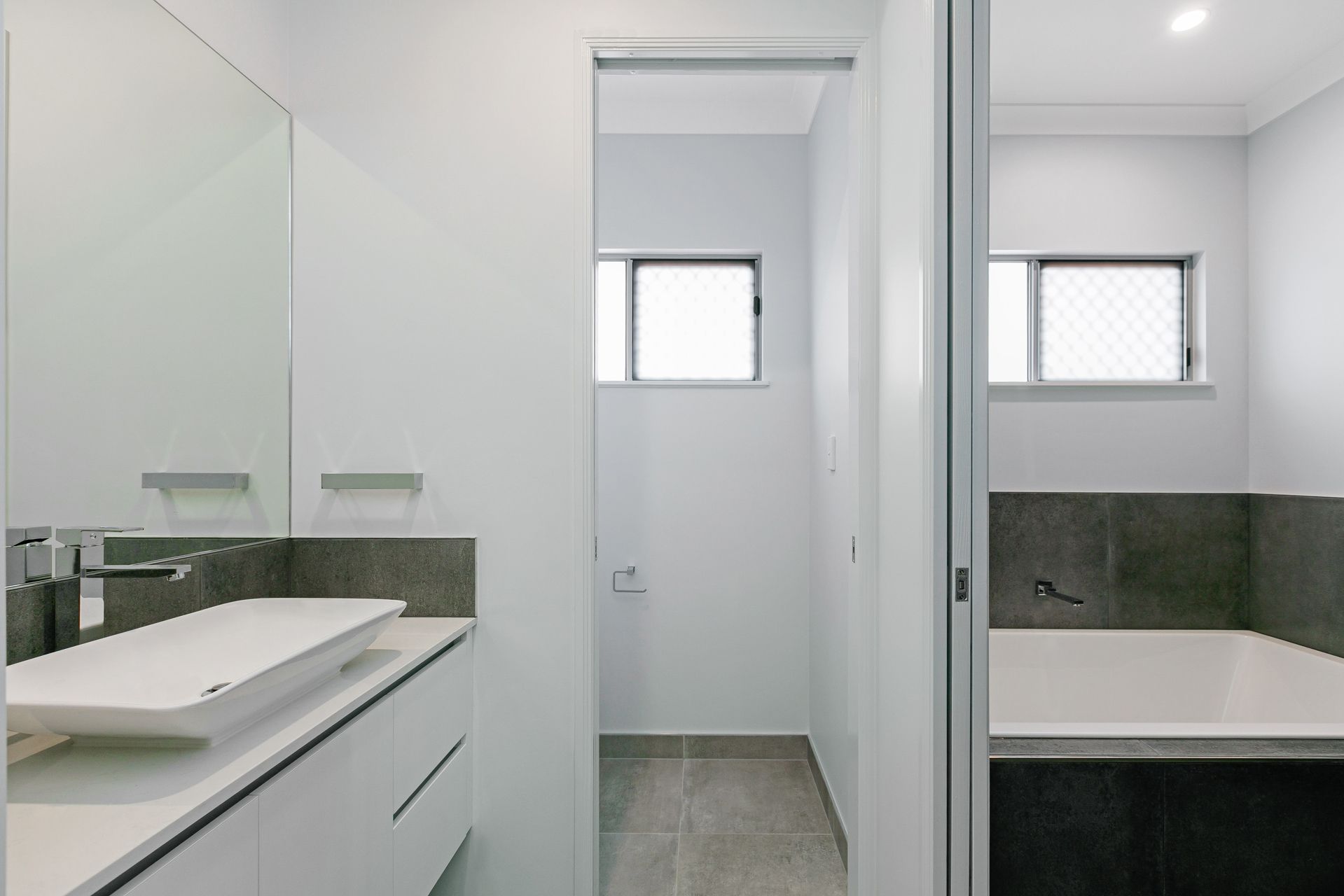 A Modern Bathroom Featuring a White Vanity With a Vessel Sink — Ashlee Jones Homes in Gordonvale, QLD