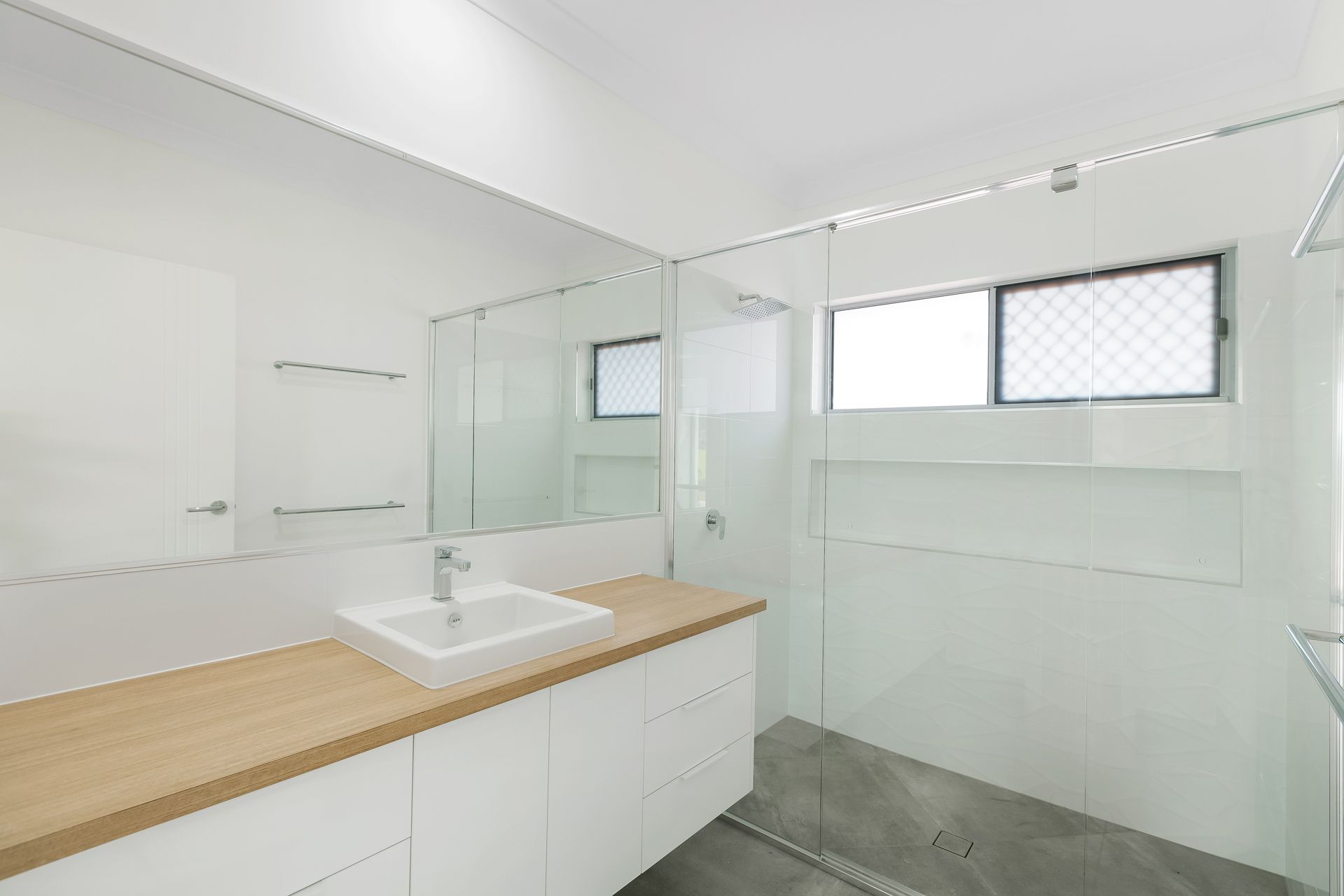 A Bright, Modern Bathroom Featuring a White Vanity — Ashlee Jones Homes in Gordonvale, QLD