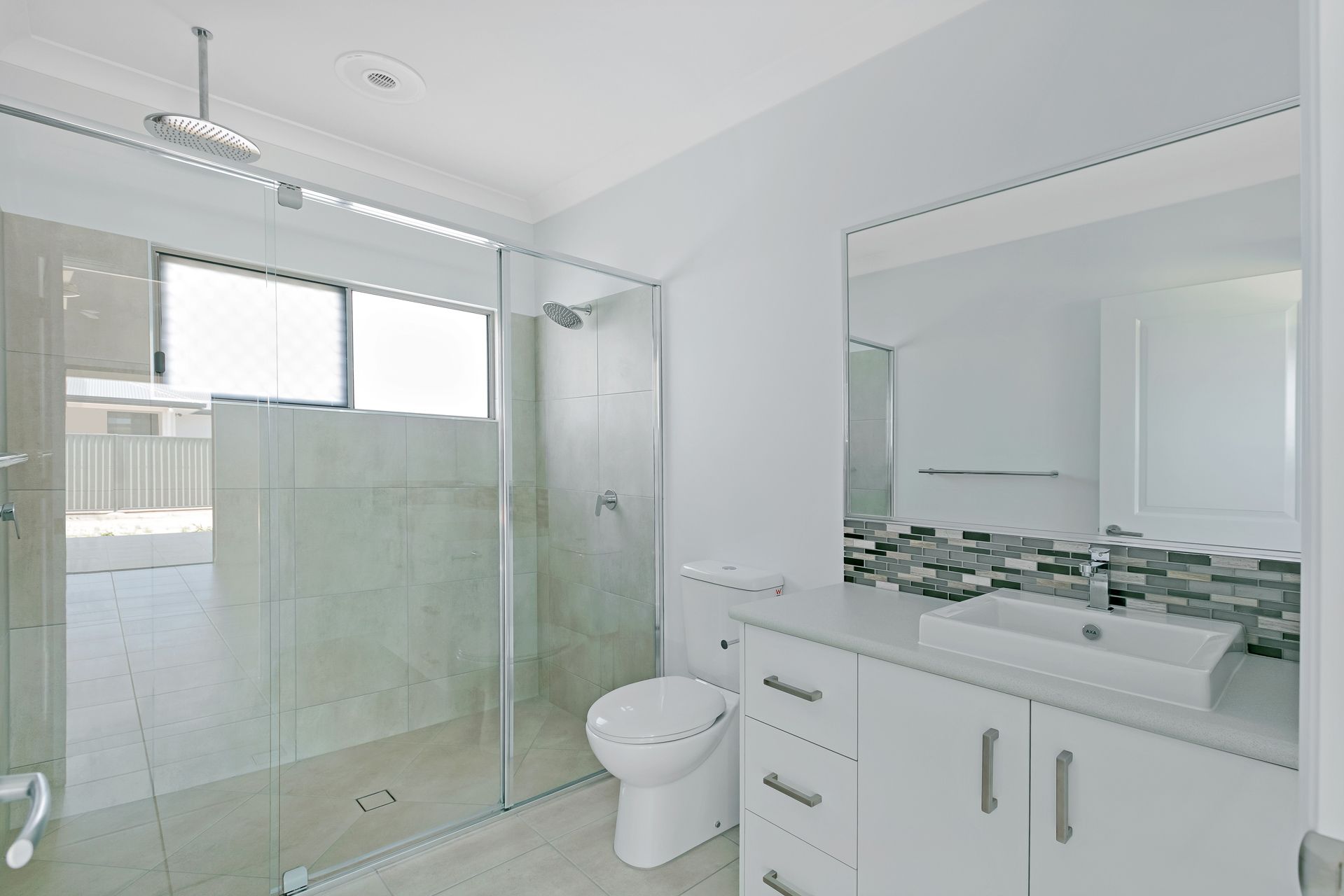 A Bright, Modern Bathroom Featuring a Glass-enclosed Shower — Ashlee Jones Homes in Gordonvale, QLD
