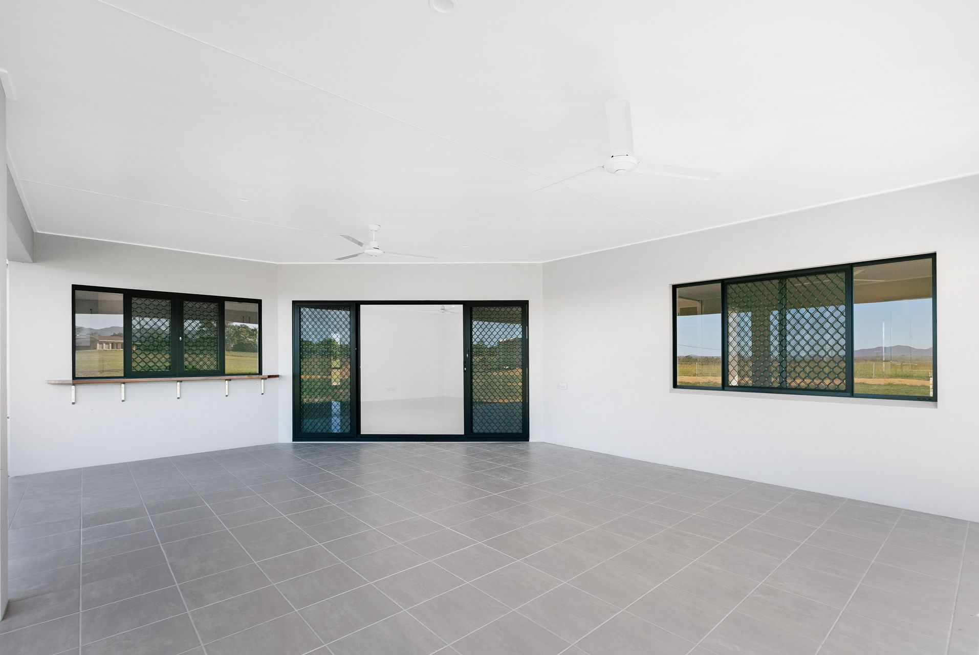 A Spacious, Minimalist Outdoor Patio With Grey Tiled Floors — Ashlee Jones Homes in Gordonvale, QLD
