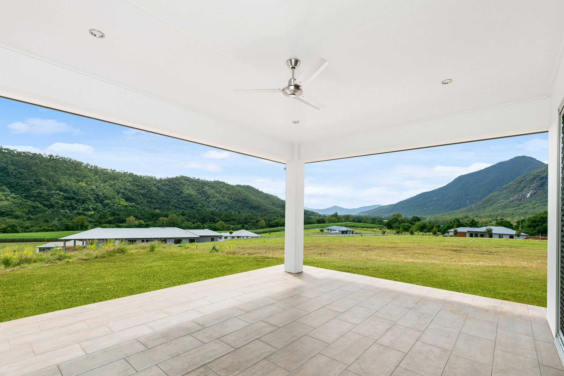 A View From a Tiled Covered Patio Overlooking a Grassy Field — Ashlee Jones Homes in Gordonvale, QLD