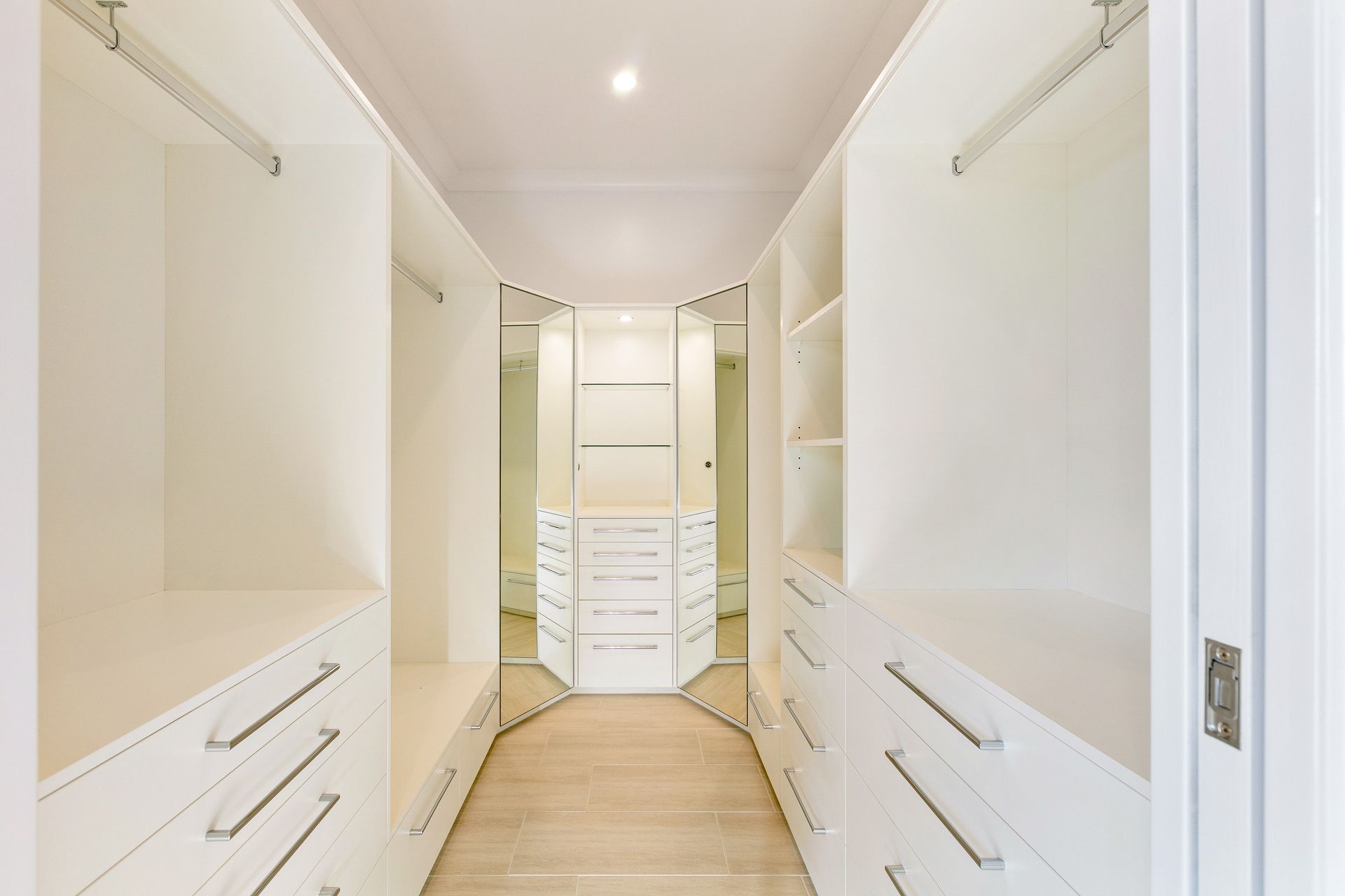 A Bright, Modern Walk-in Closet With White Cabinetry — Ashlee Jones Homes in Gordonvale, QLD
