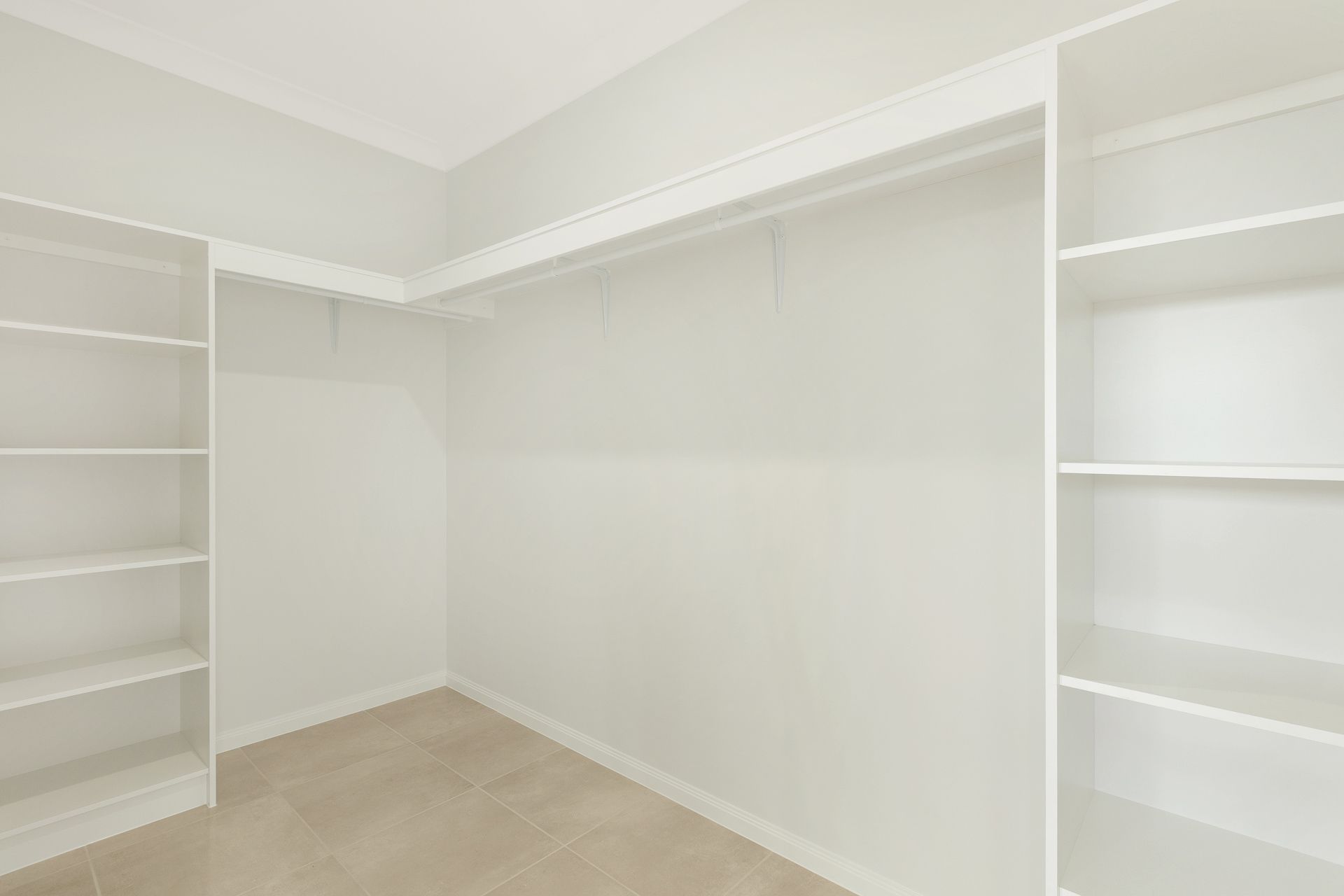 Empty Walk-in Closet Featuring White Shelves — Ashlee Jones Homes in Gordonvale, QLD