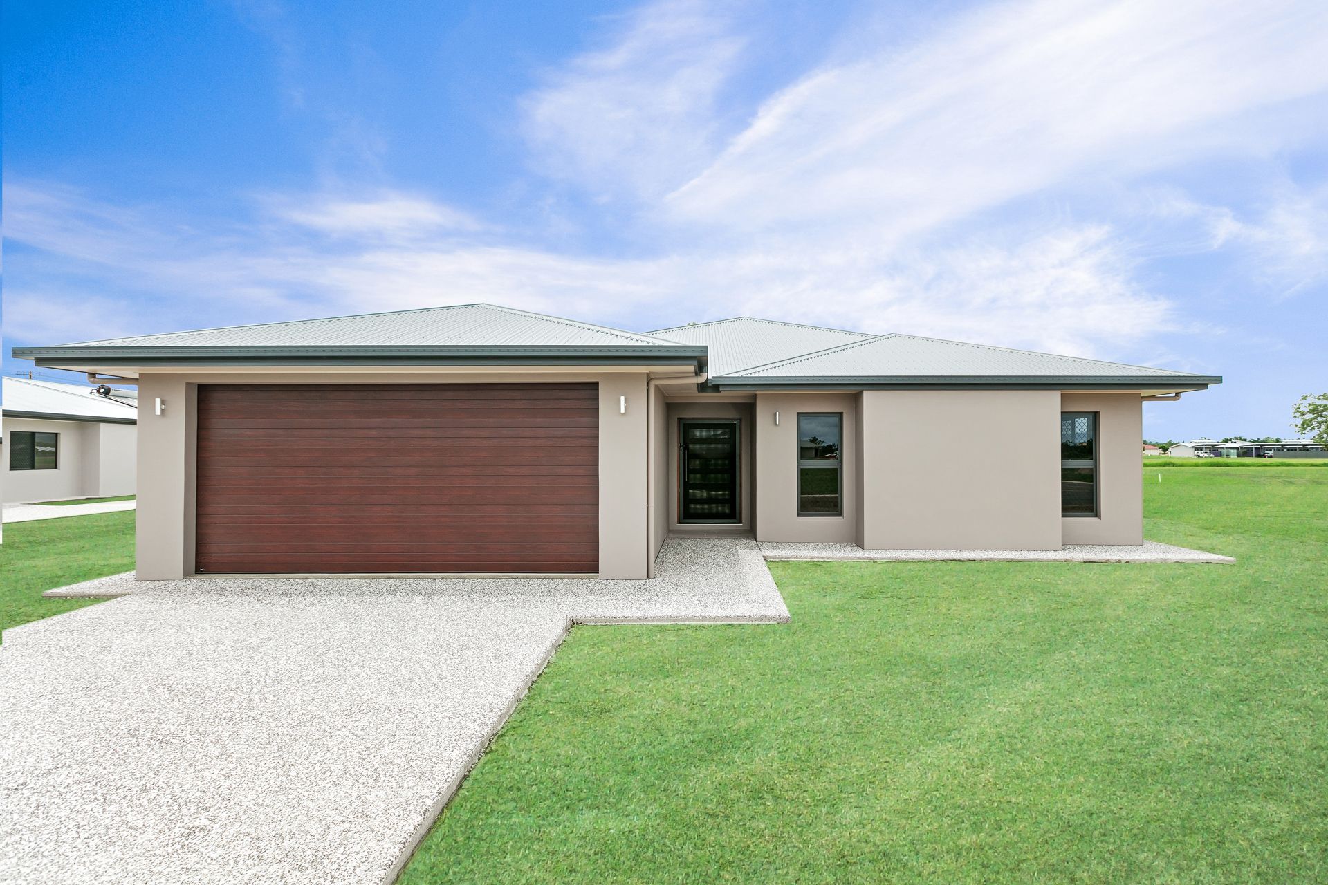 A Single-story, Beige Suburban House With a Large Wooden Garage Door — Ashlee Jones Homes in Gordonvale, QLD