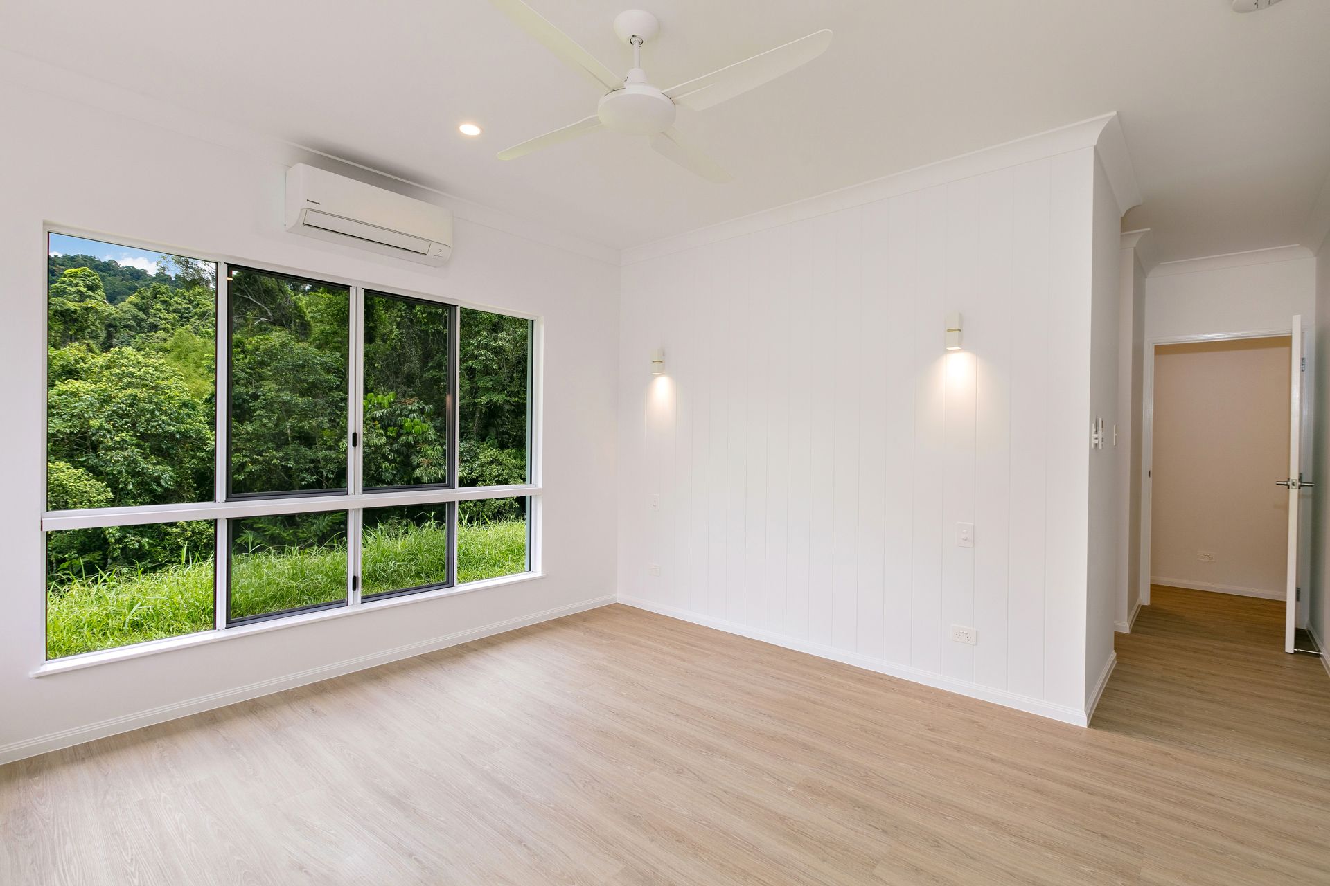 A Bright, Empty Room With White Walls, Wood-look Flooring — Ashlee Jones Homes in Gordonvale, QLD
