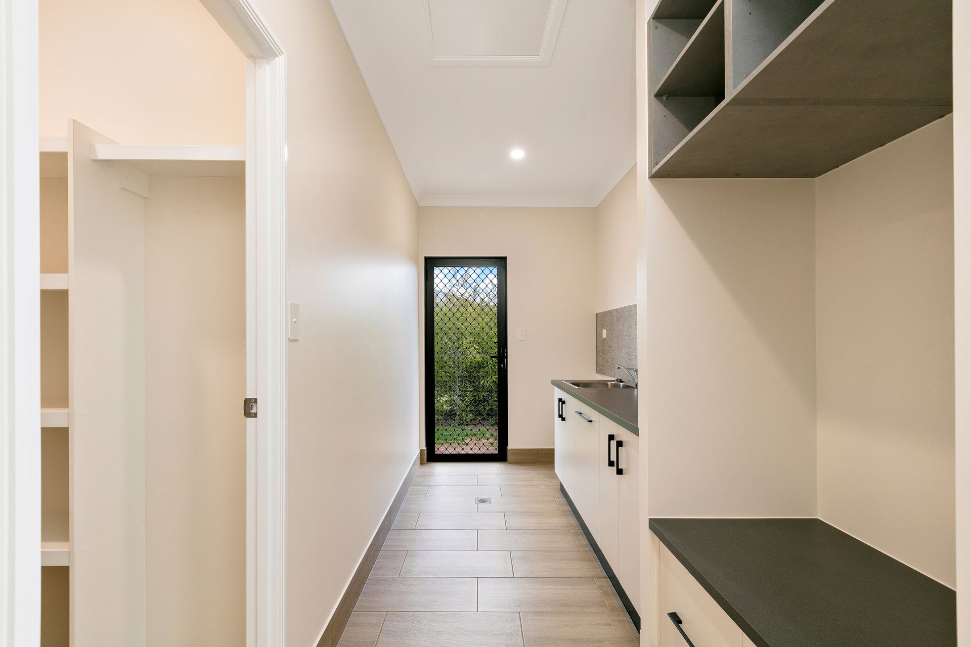 A Modern Laundry Room With White Cabinets — Ashlee Jones Homes in Gordonvale, QLD