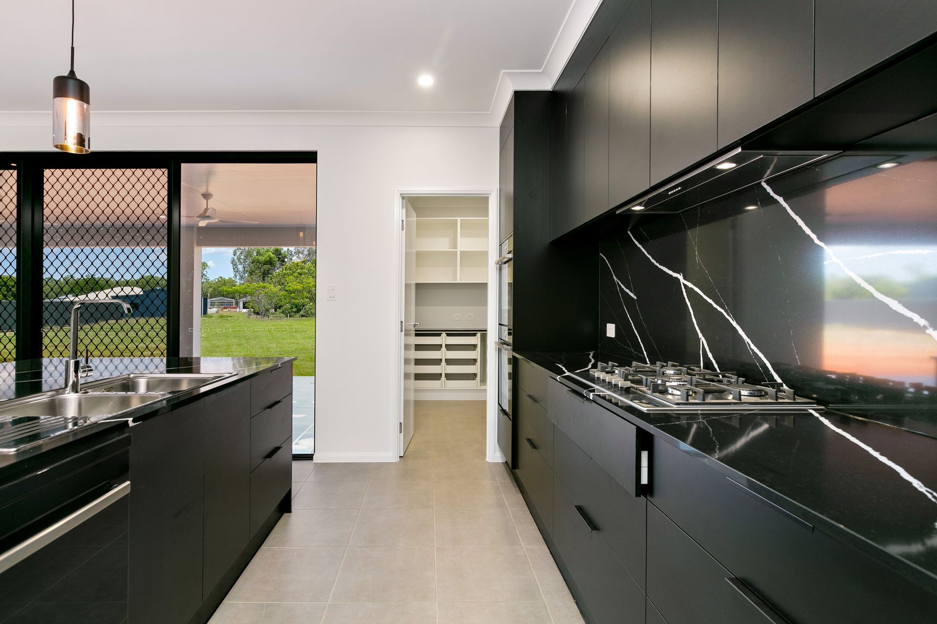 A Modern Kitchen With Matte Black Cabinetry — Ashlee Jones Homes in Gordonvale, QLD