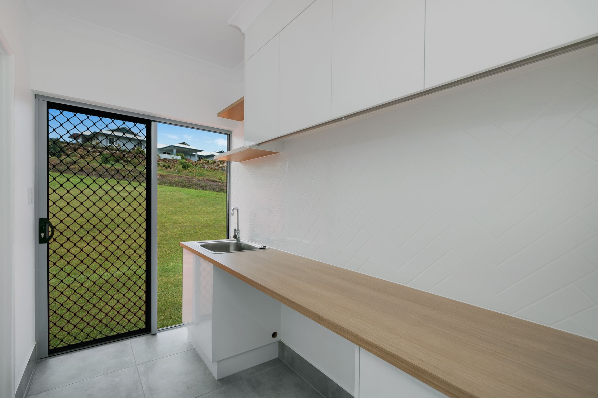 Modern Laundry Room With White Cabinets — Ashlee Jones Homes in Gordonvale, QLD