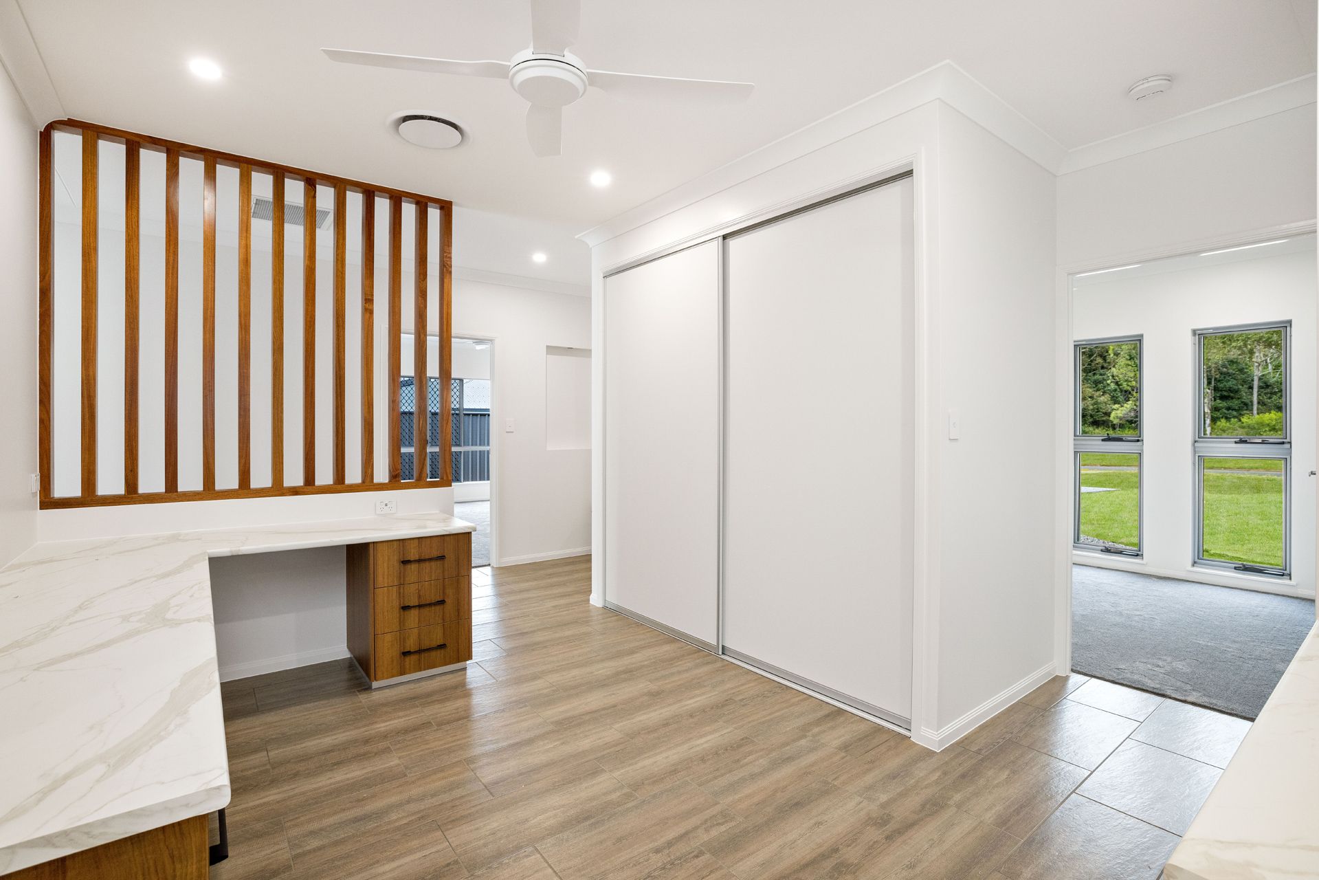 Modern Room With Wood-look Flooring, White Sliding Closet Doors — Ashlee Jones Homes in Gordonvale, QLD