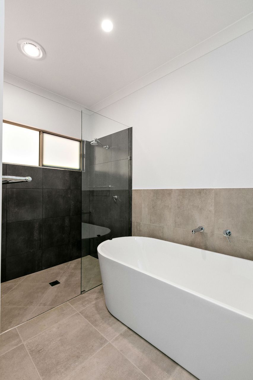 Modern Bathroom Featuring a White Freestanding Bathtub — Ashlee Jones Homes in Gordonvale, QLD