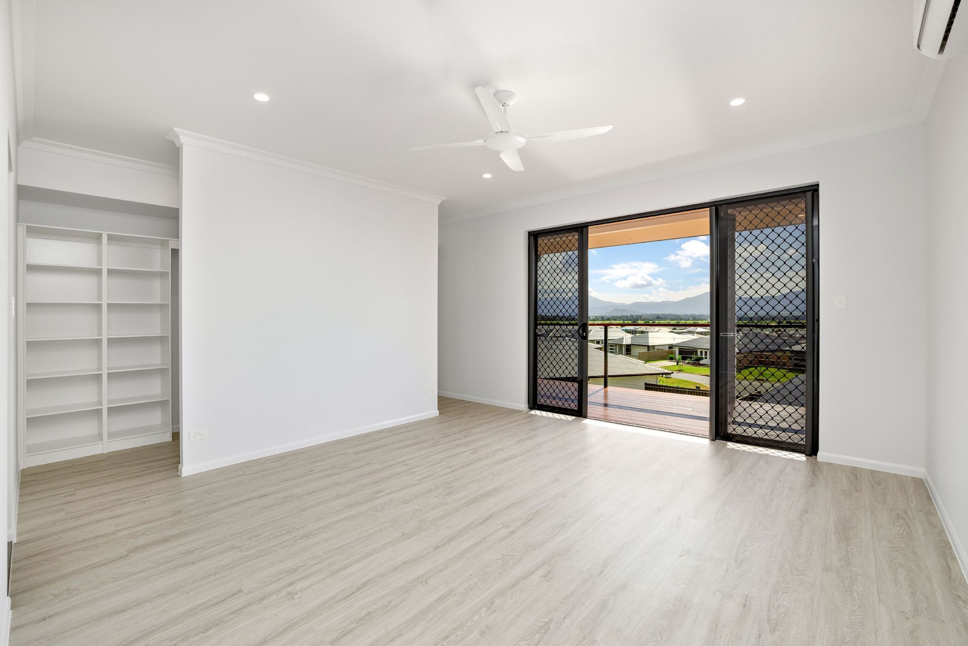 A Bright, Unfurnished Room With Light Wood Floors — Ashlee Jones Homes in Gordonvale, QLD