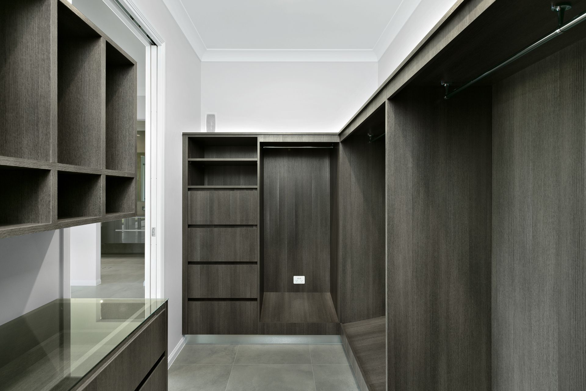 A Walk-in Closet With Dark Wood Shelving — Ashlee Jones Homes in Gordonvale, QLD