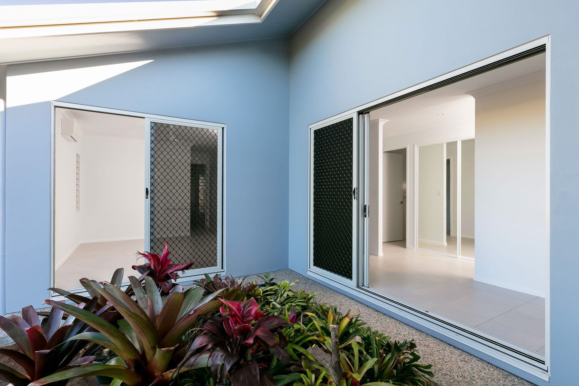 Modern Light Blue Exterior Walls With Sliding Glass Doors — Ashlee Jones Homes in Gordonvale, QLD