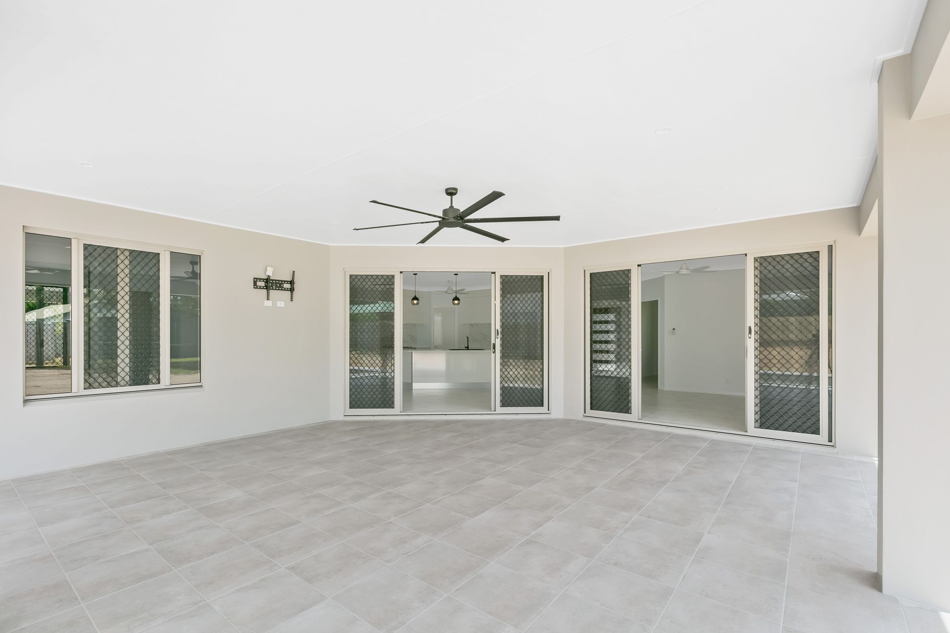 A Spacious, Tiled Outdoor Covered Patio With a Ceiling Fan — Ashlee Jones Homes in Gordonvale, QLD