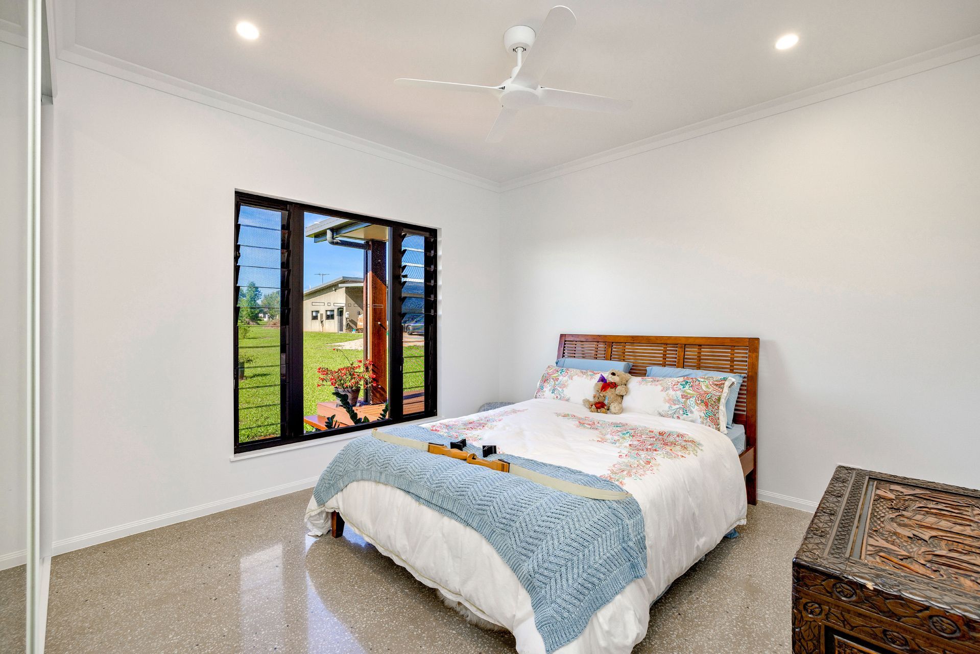 A Bedroom With a Queen Bed, White Walls, Polished Tiled Floors — Ashlee Jones Homes in Gordonvale, QLD