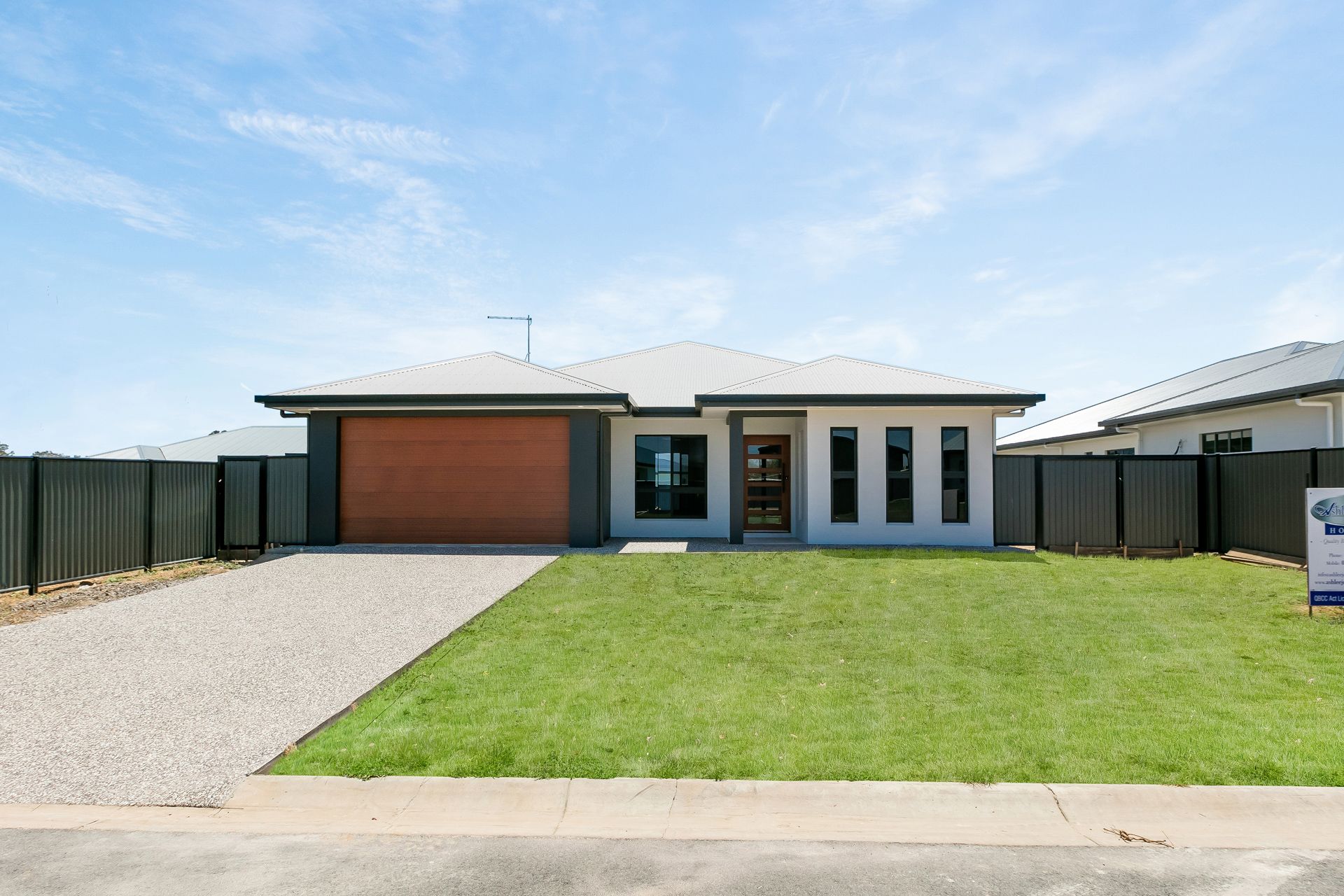 A Single-story Suburban House With a Wood-toned Garage Door — Ashlee Jones Homes in Gordonvale, QLD
